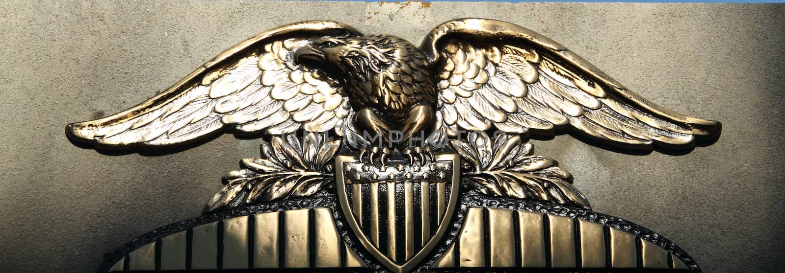 A brass carving of a bald eagle over and american sheild.