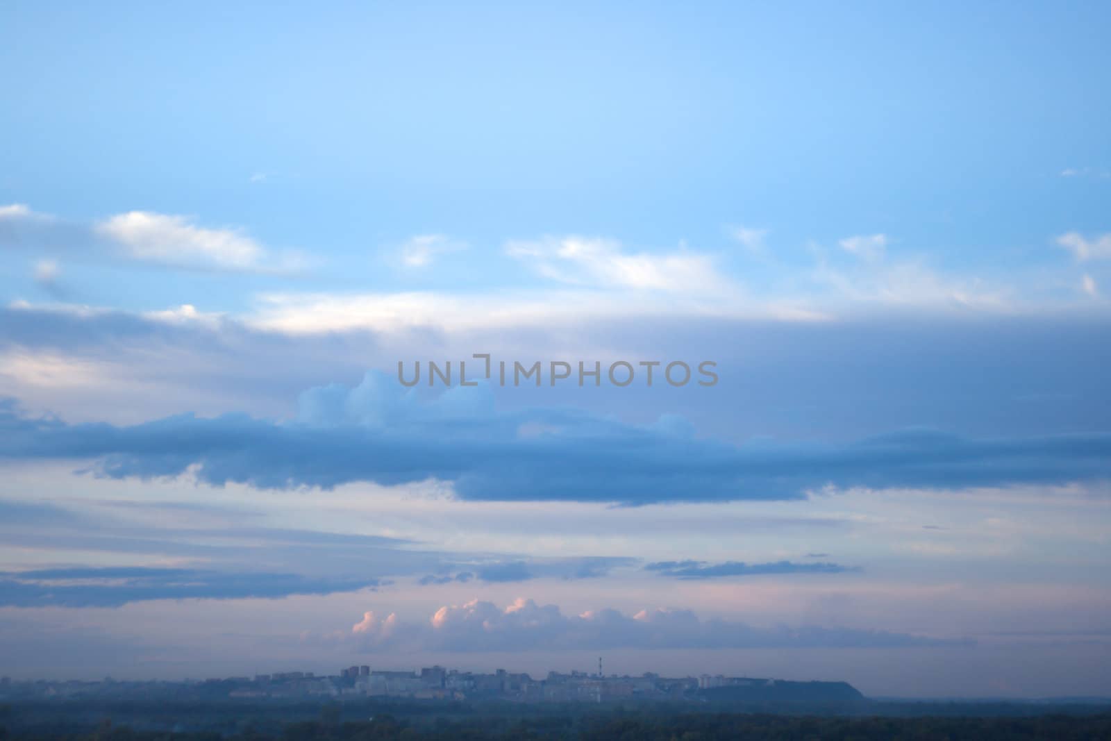 Blue sky with clouds above city in the evening during a decline