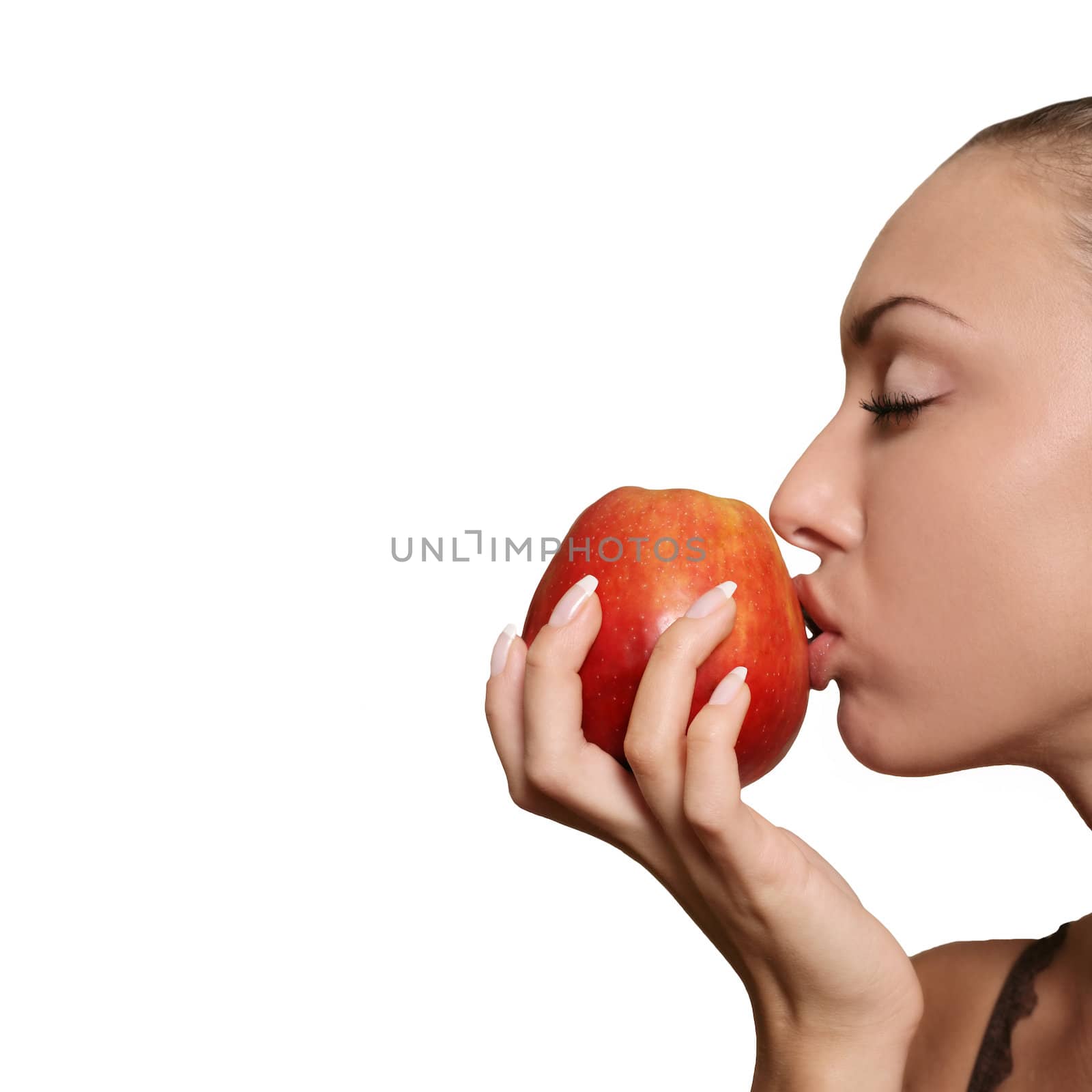 The girl kisses a red apple isolated in white