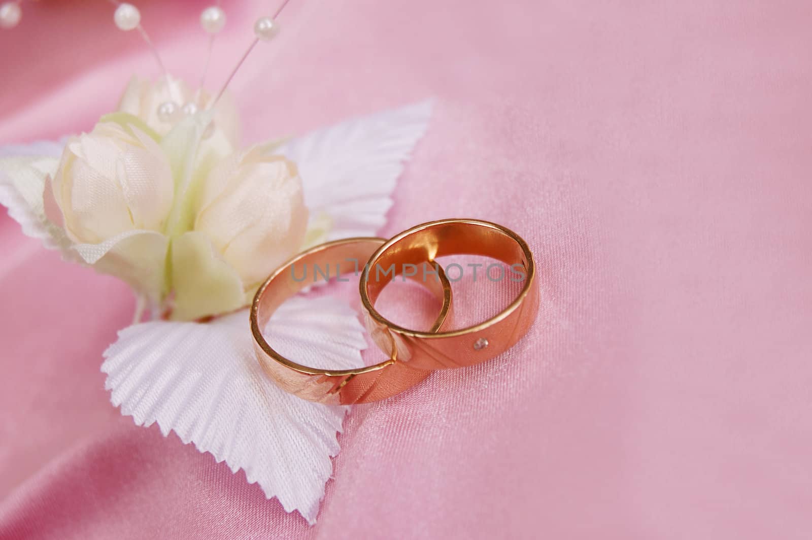 wedding golden rings with decoration on pink satin