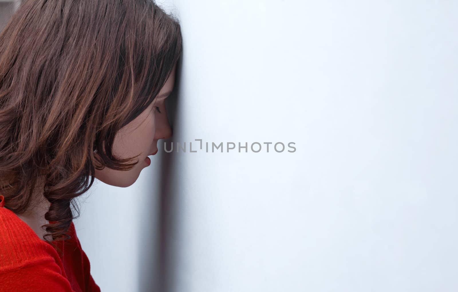 Tensed young woman leaning on a wall 