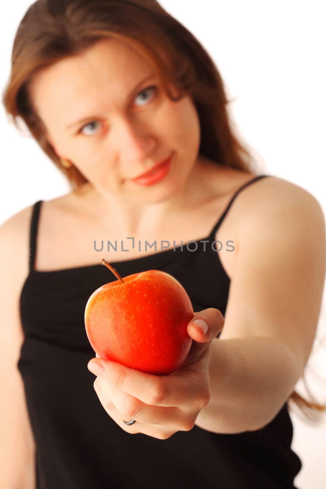 Young pretty woman offering a red apple, focus on hand, isolated over white background 