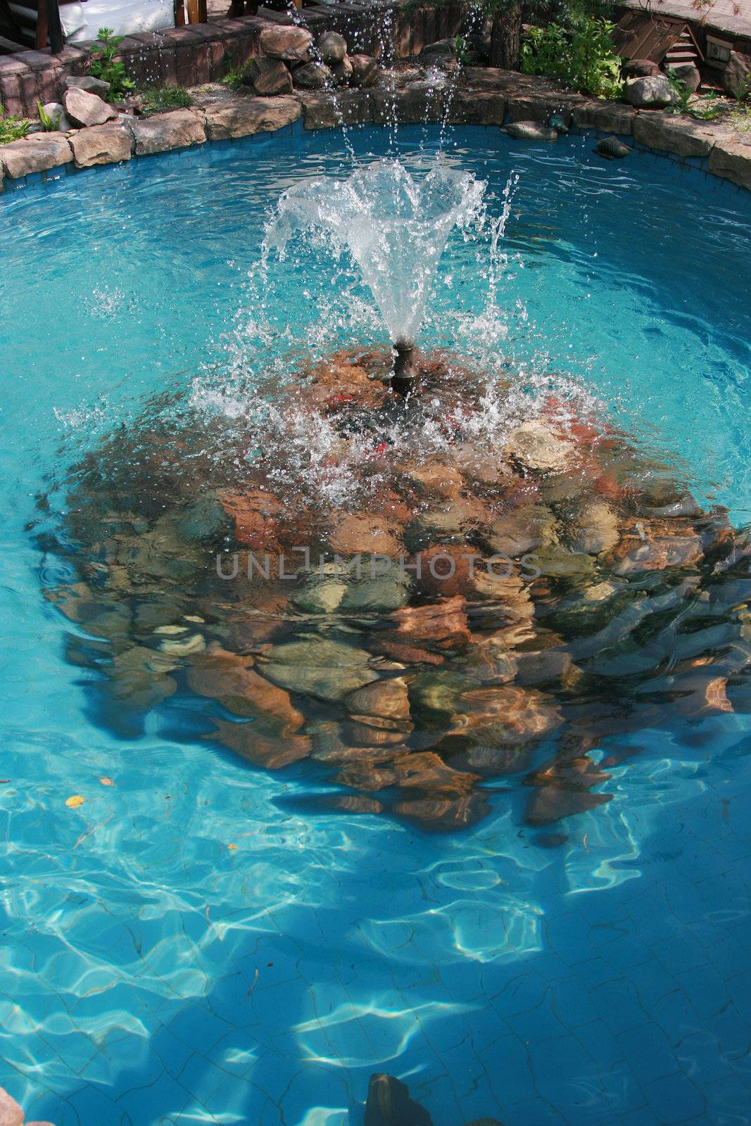 Small freshening fountain in blue pool