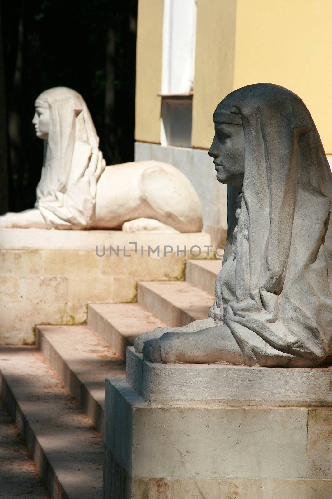 Two statues protect an input on steps