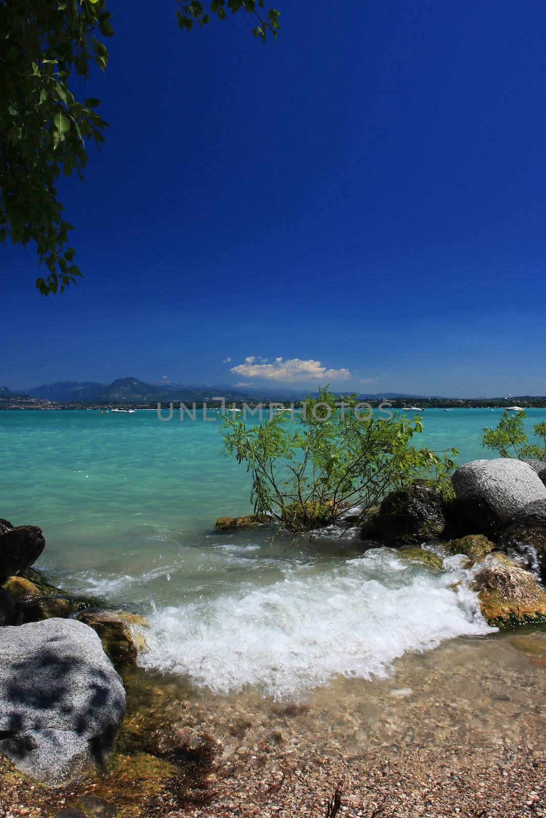 Small waves crashing on the beach, deep blue sky and fantastically colored green water, copy space in sky, Great concept shot