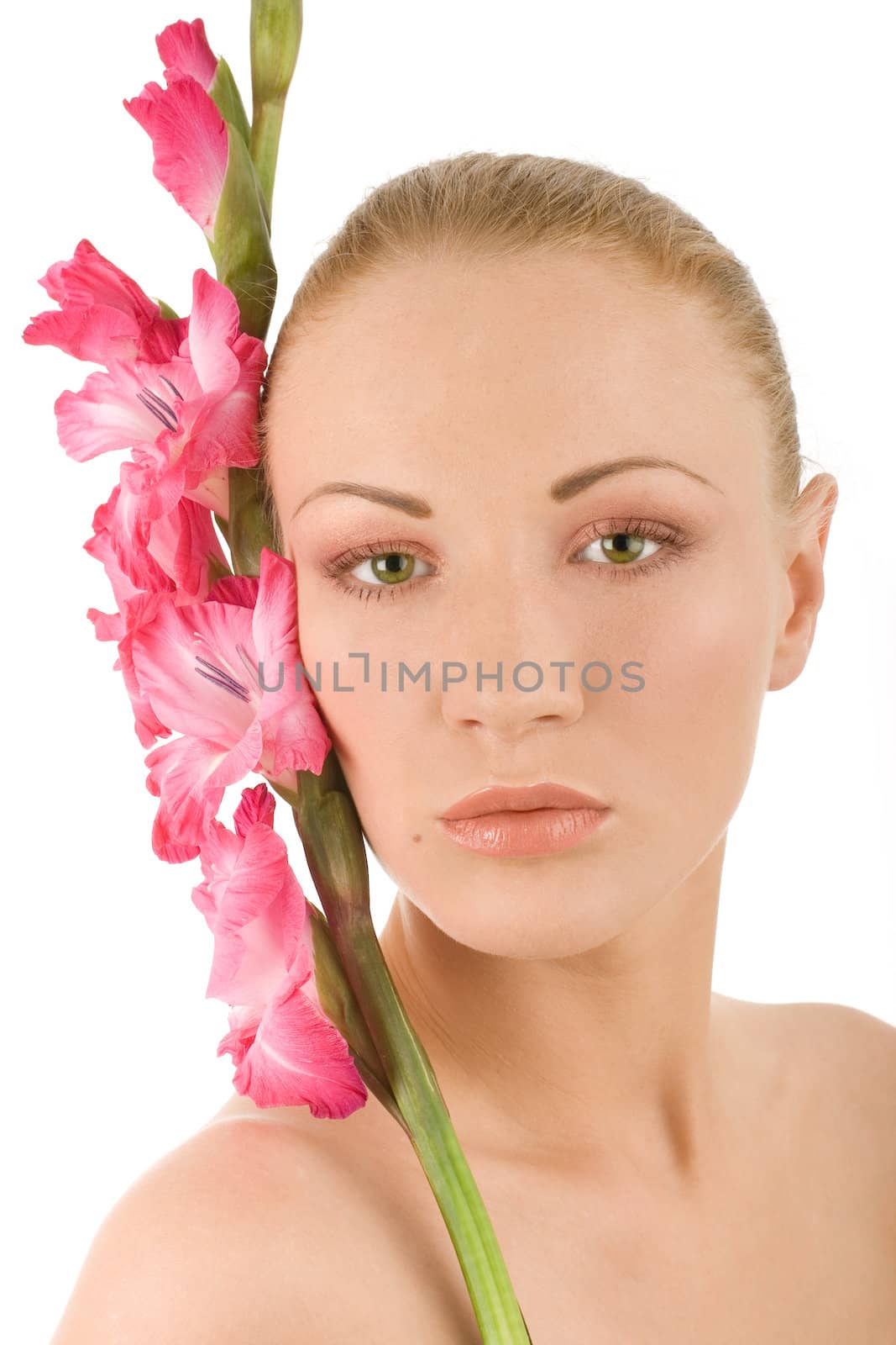 Young woman in spa with fresh pink gladiolus
