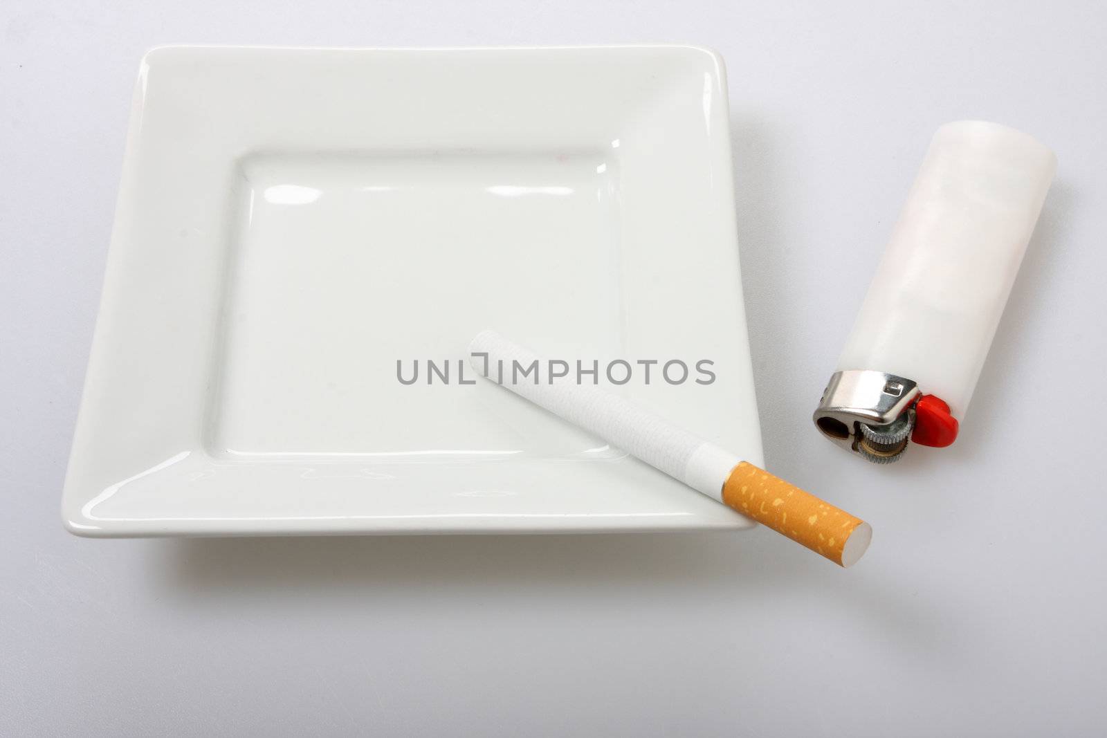 unlit cigarette on white ashtray isolated on white white lighter to the side