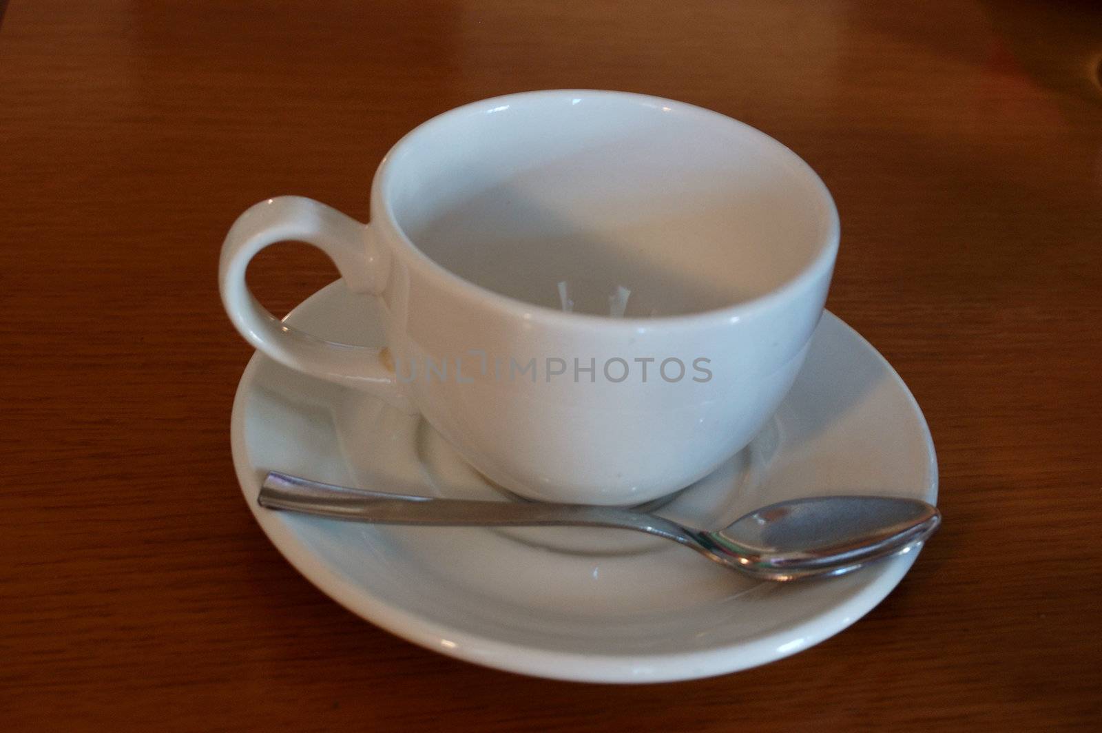 Close-up of empty white teacup and teaspoon