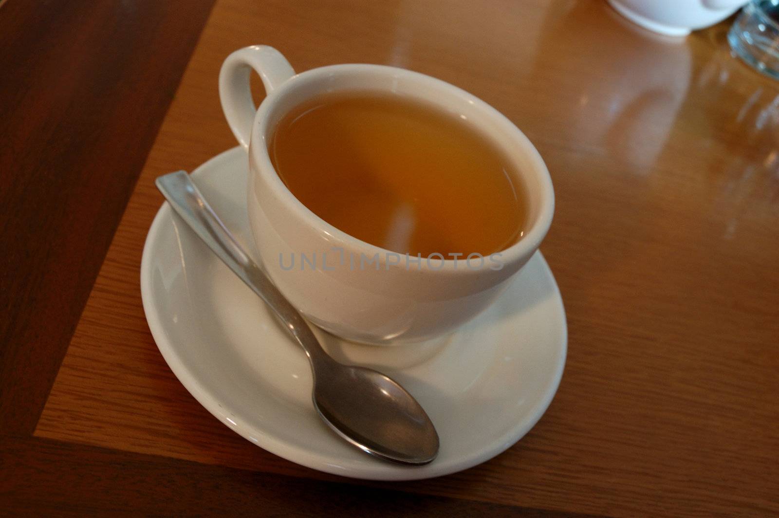 Close-up of white teacup  of green tea and teaspoon