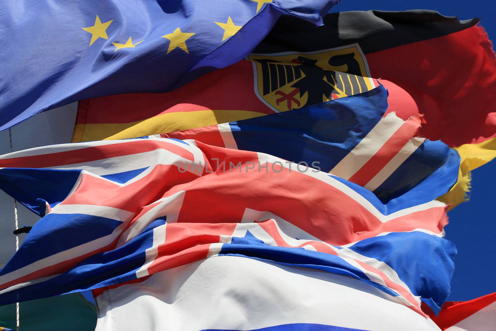The national flags of France, UK and Germany along with the European Union flag all flying together, thight shot. 