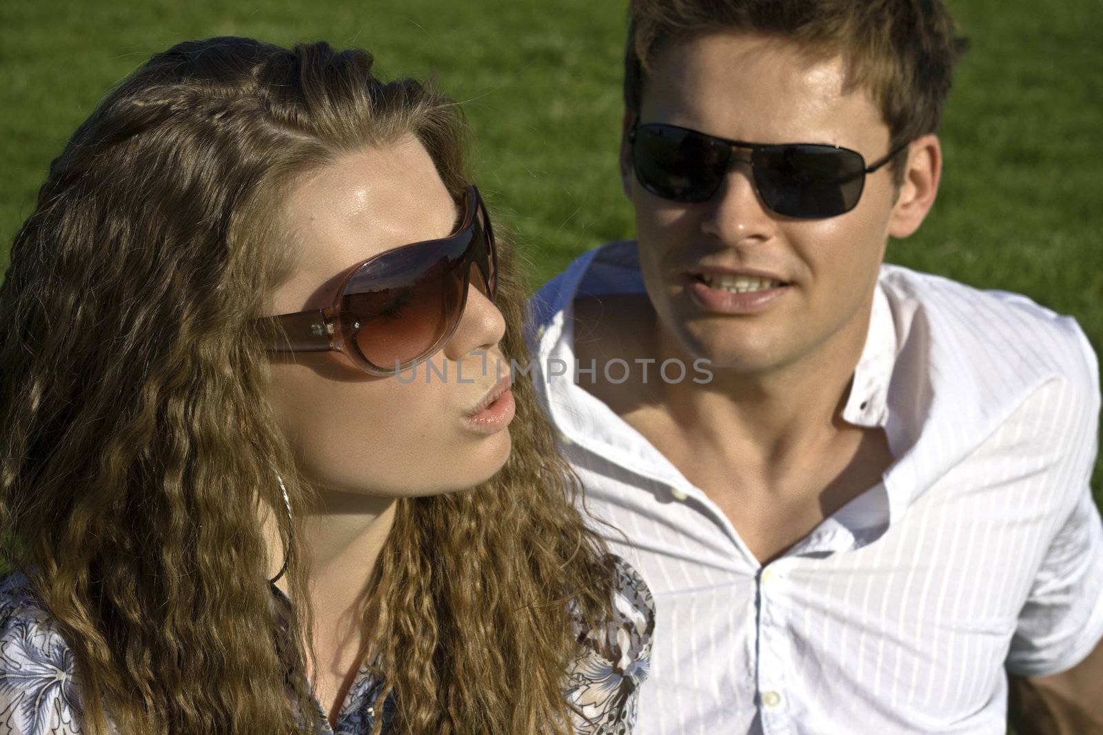Closeup Of A Couple With Sunglasses Sitting On Grass