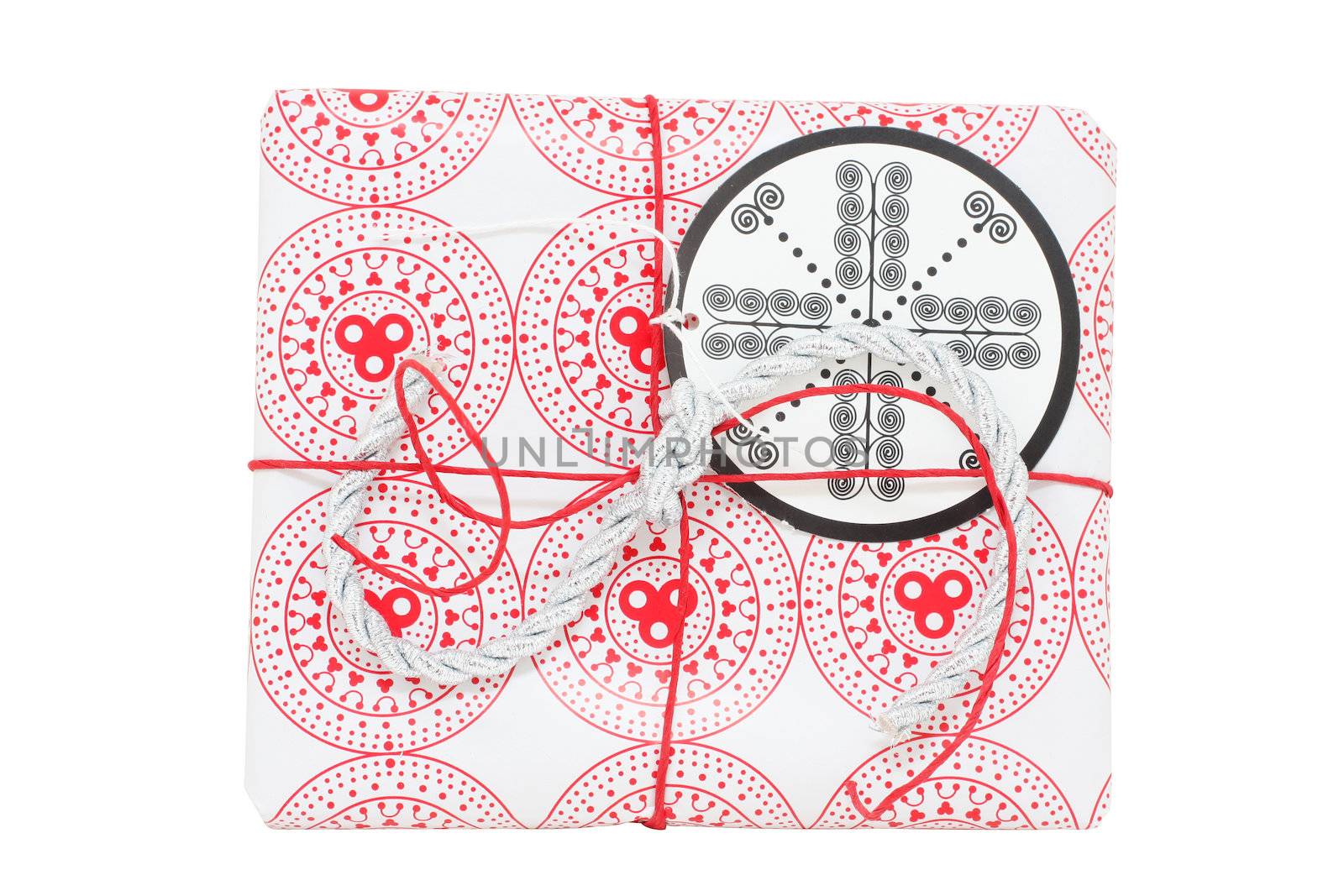 A gift wrapped in red and white paper, with gift tag, isolated on white