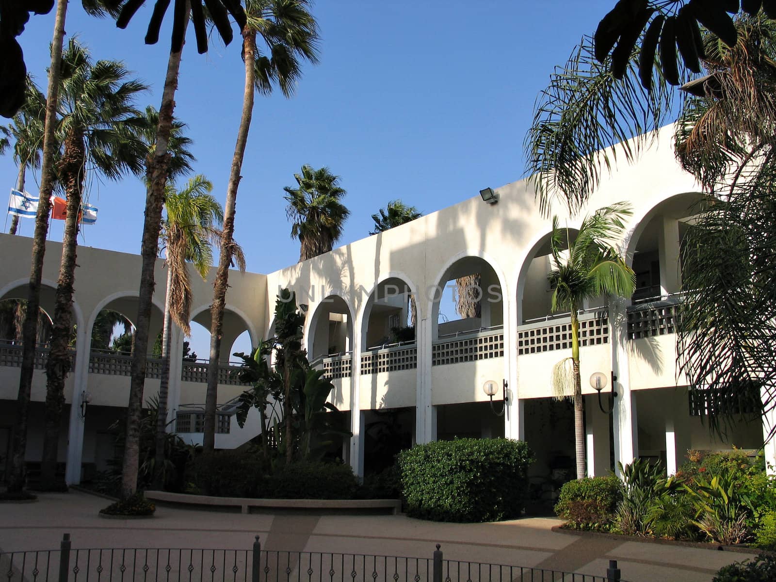 Hotel and patio with palm trees - built in Mediterranean style
