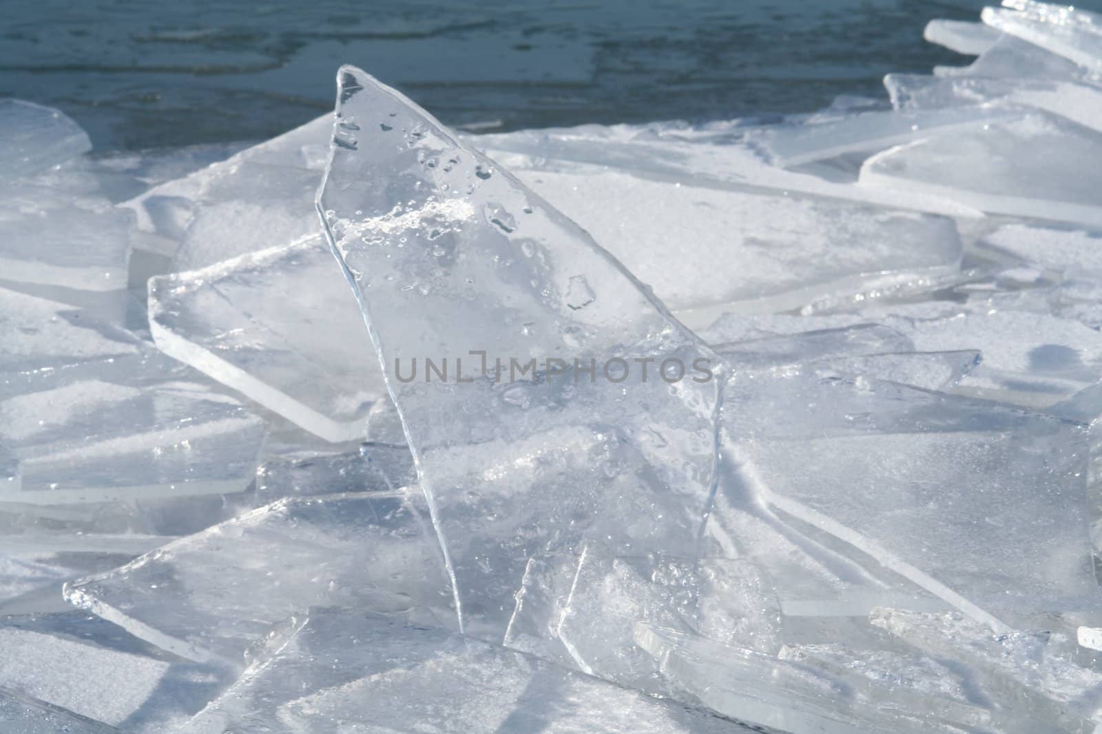 Brocken ice shinning in the winter sun and reflecting the blue sky.