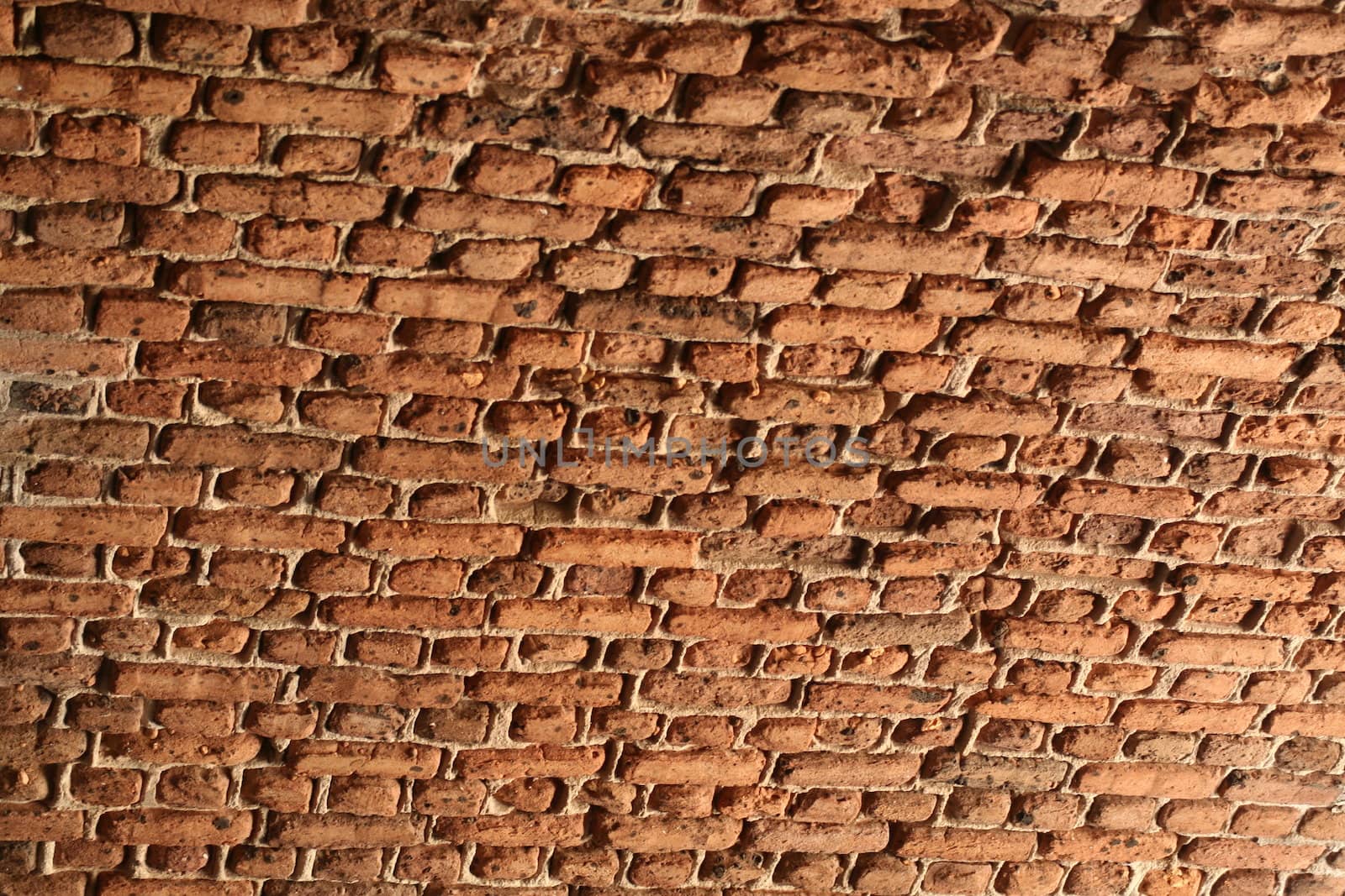 A ceiling of very weathered and aged bricks.