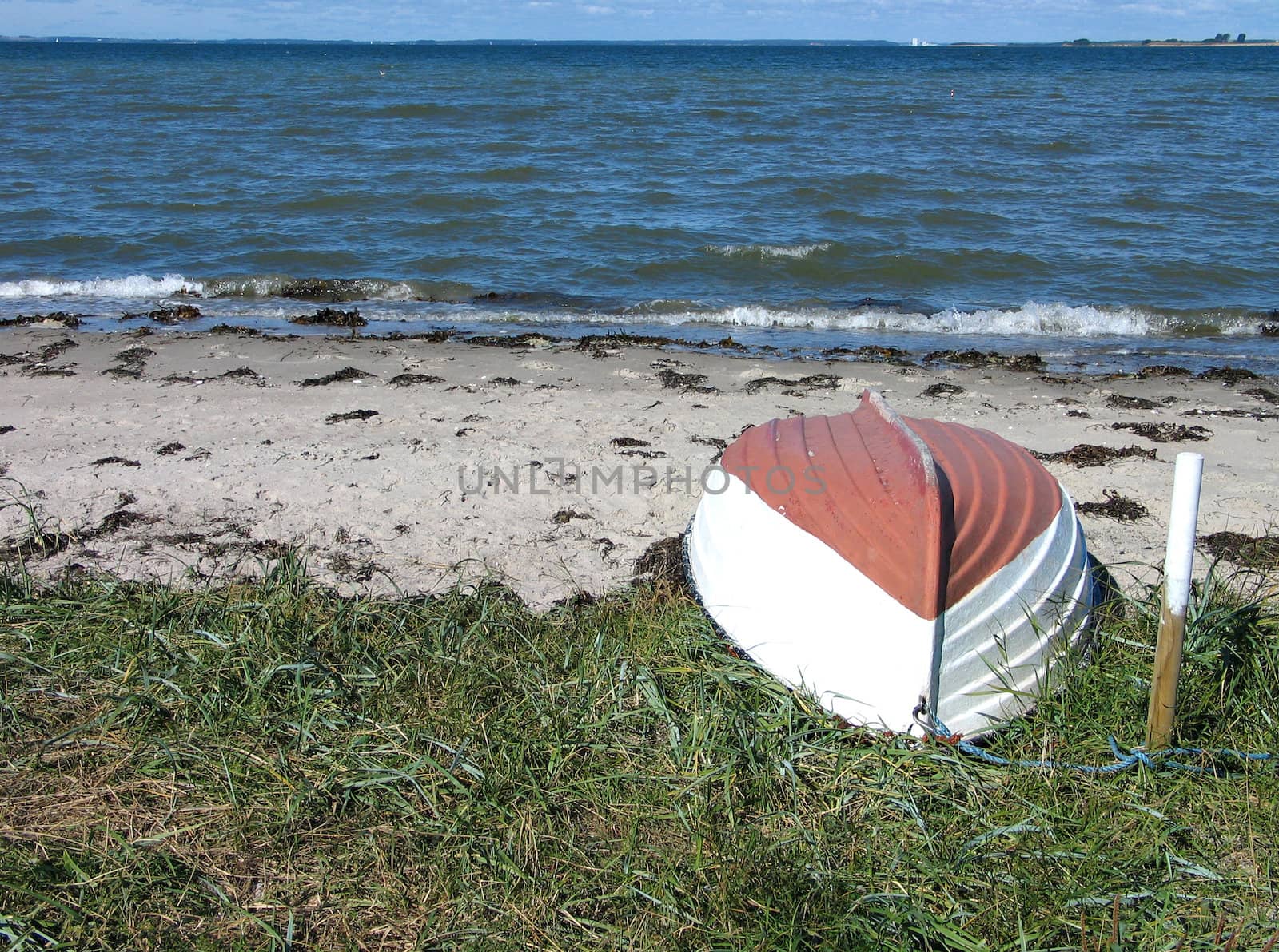 Beach landscape - small wooden boat on the sand
