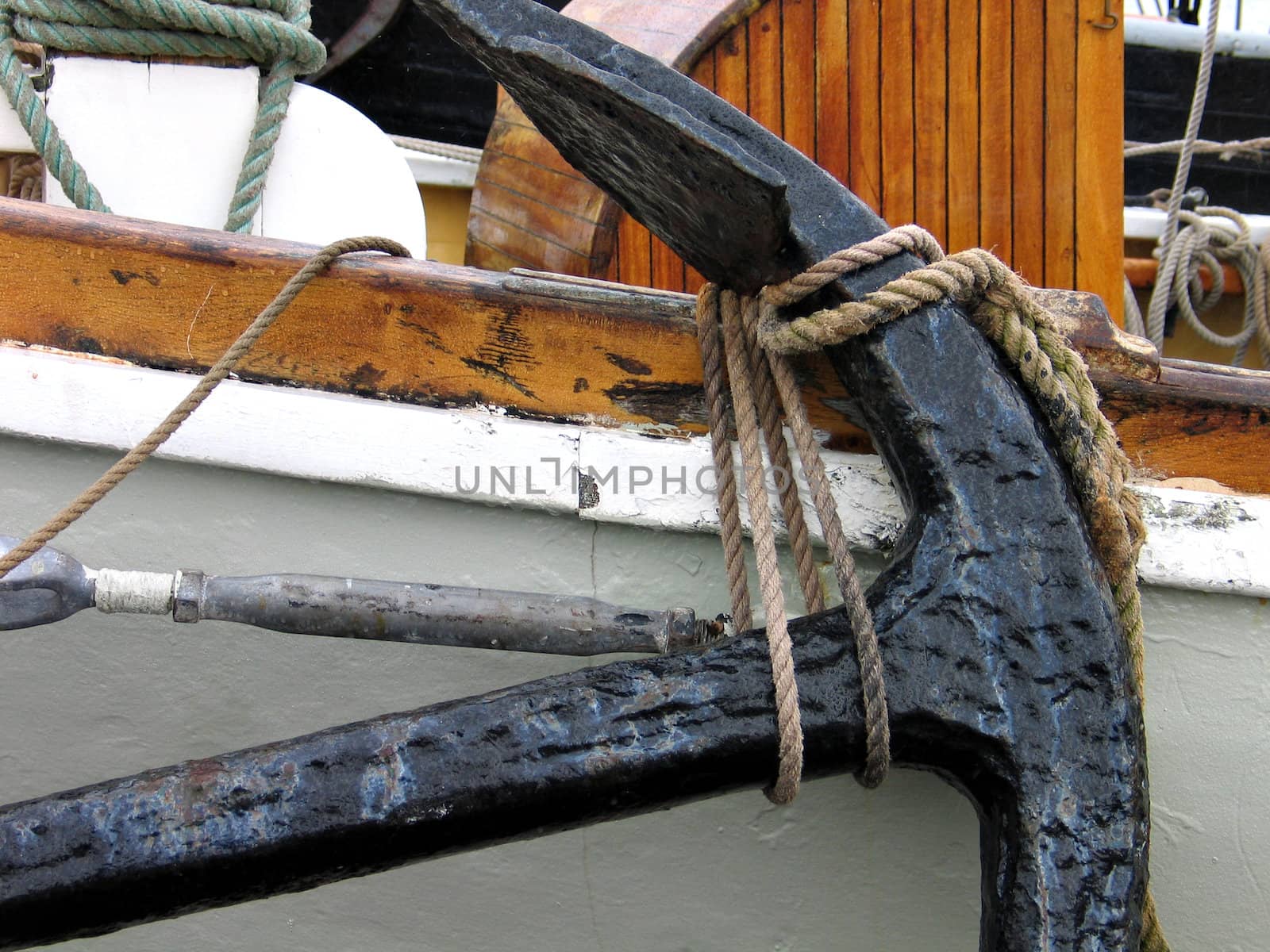 Old metal anchor on a traditional wooden boat
