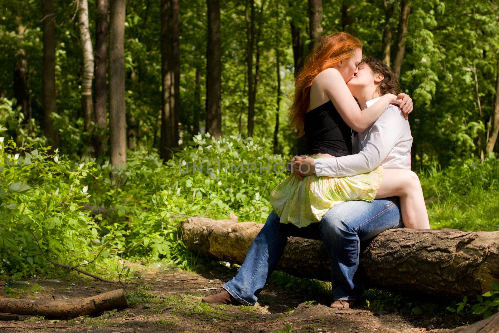 Two Girlfriends kissing in summer forest vacations