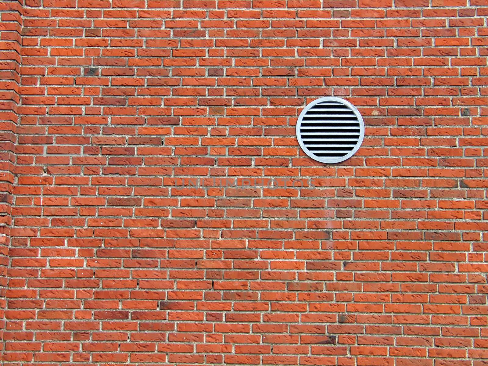 Red bricks wall with a small ventilation window - architecture abstract