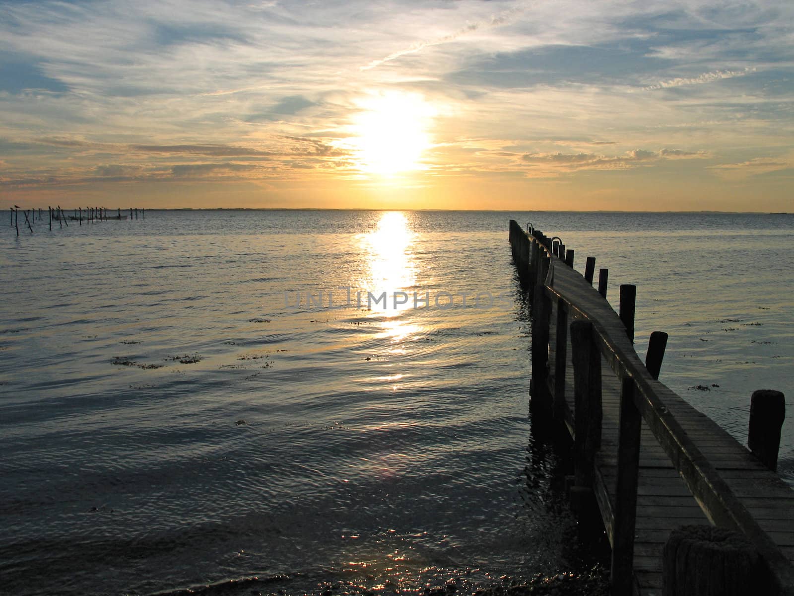 Small wooden pier with a beautiful dramatic sunset