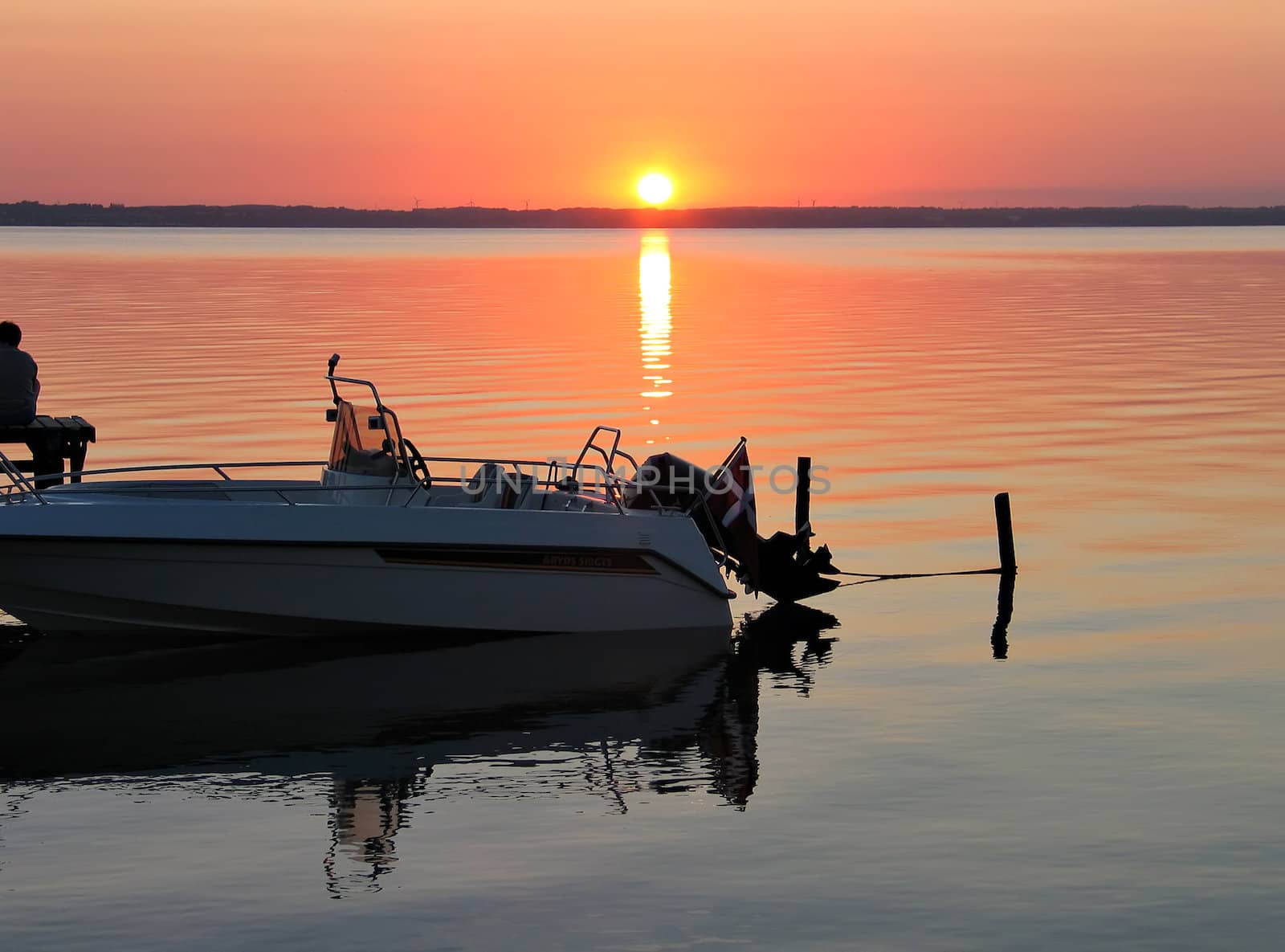 Speedboat anchored to a dock in sunset