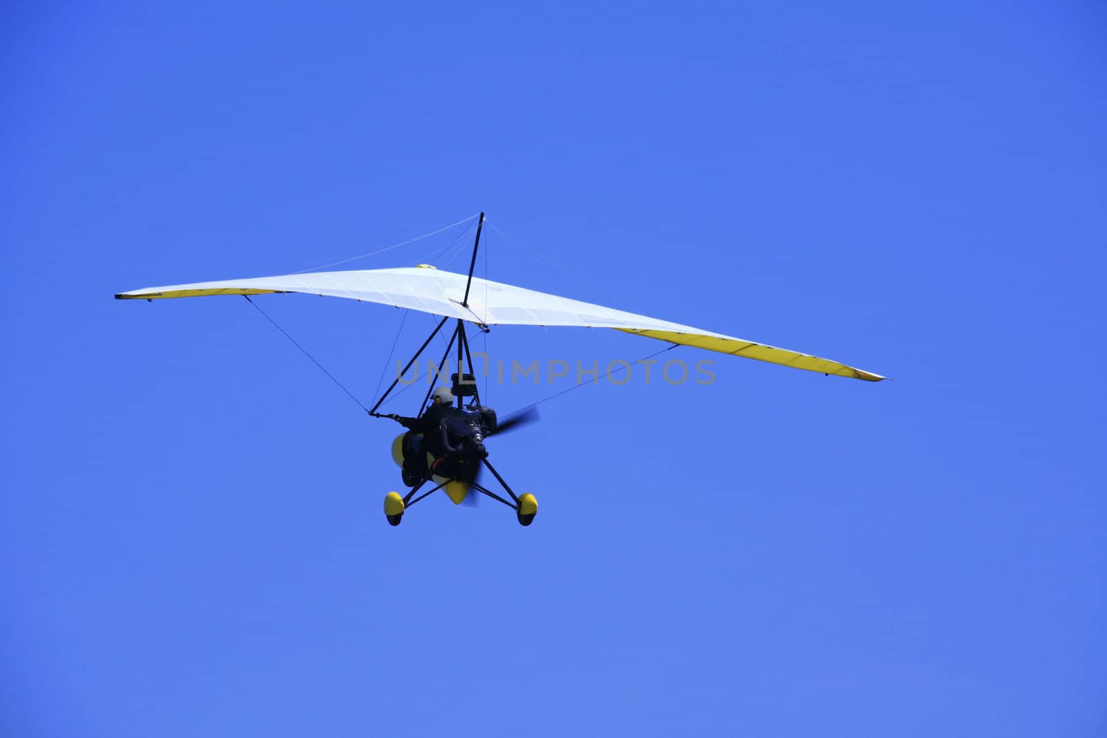 ultralight aircraft in flight against the blue sky
