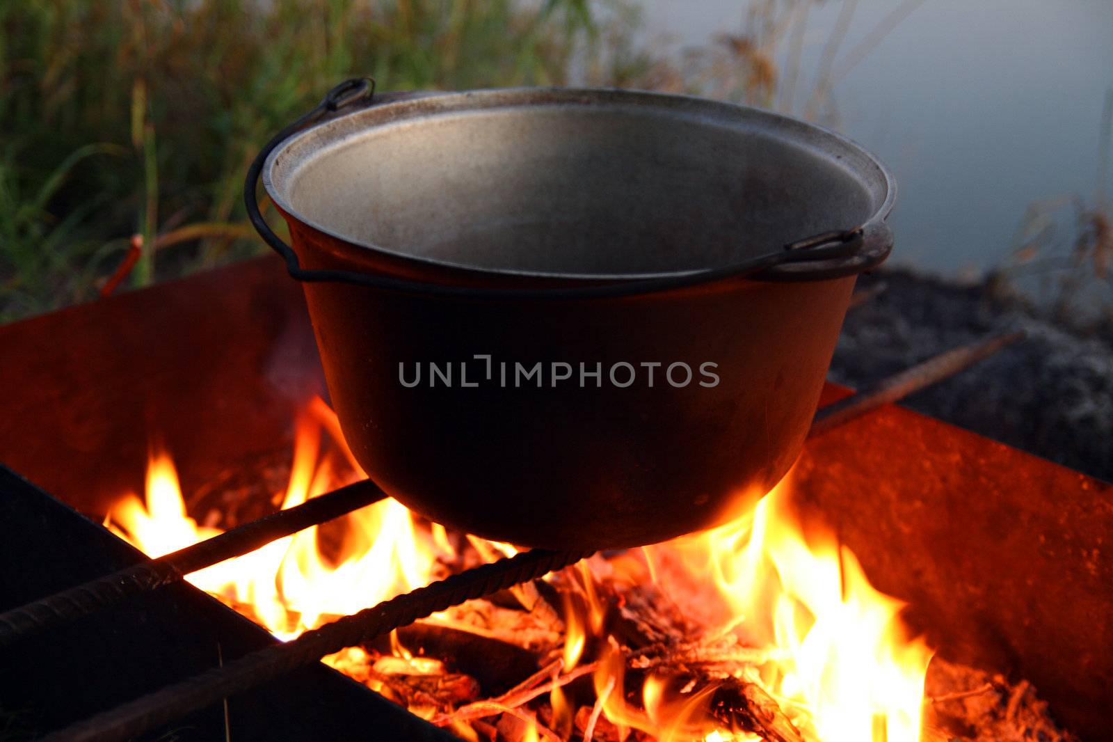 kettle over campfire near the river