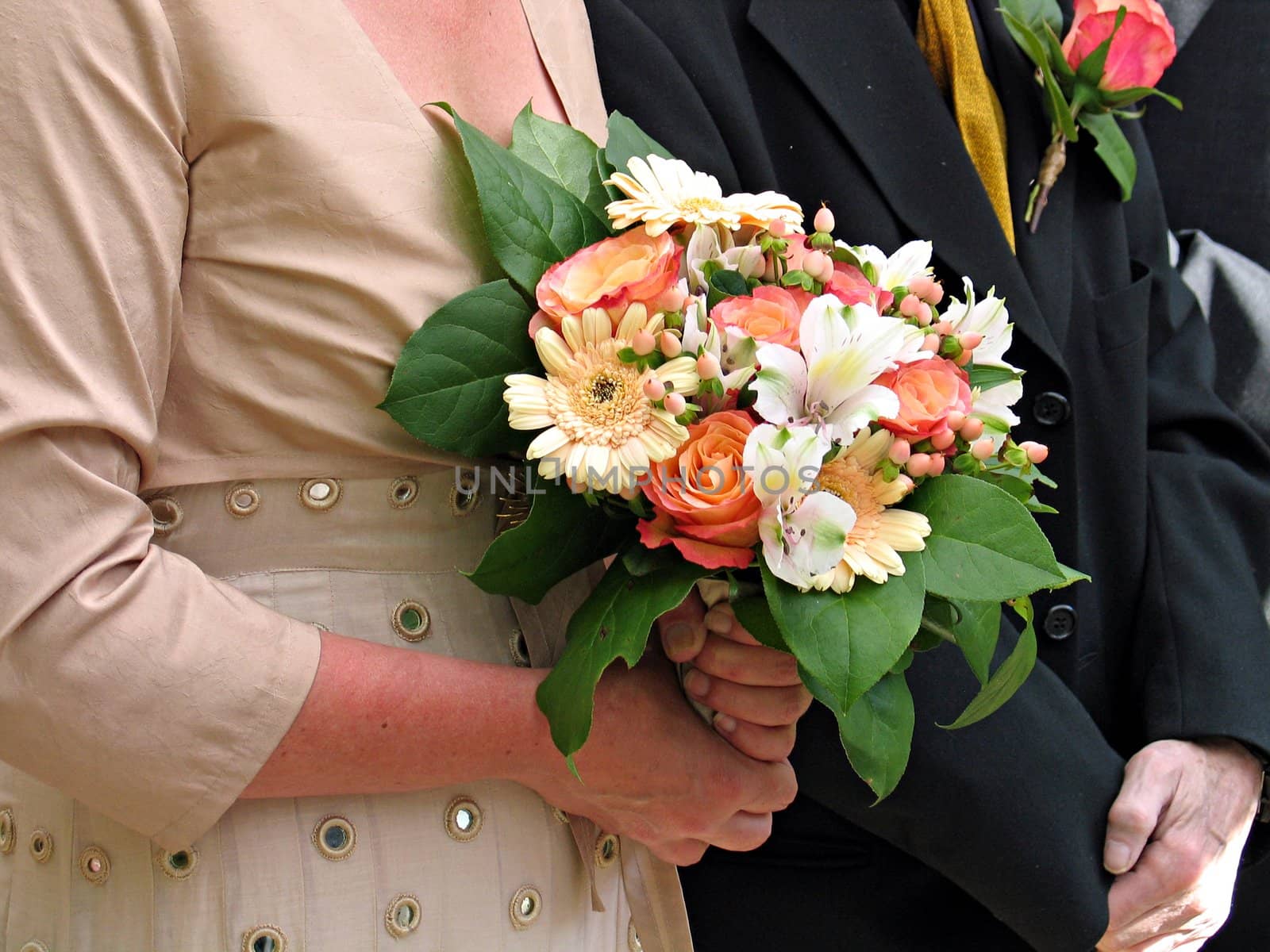 Close view of a bride, groom and a wedding bouquet