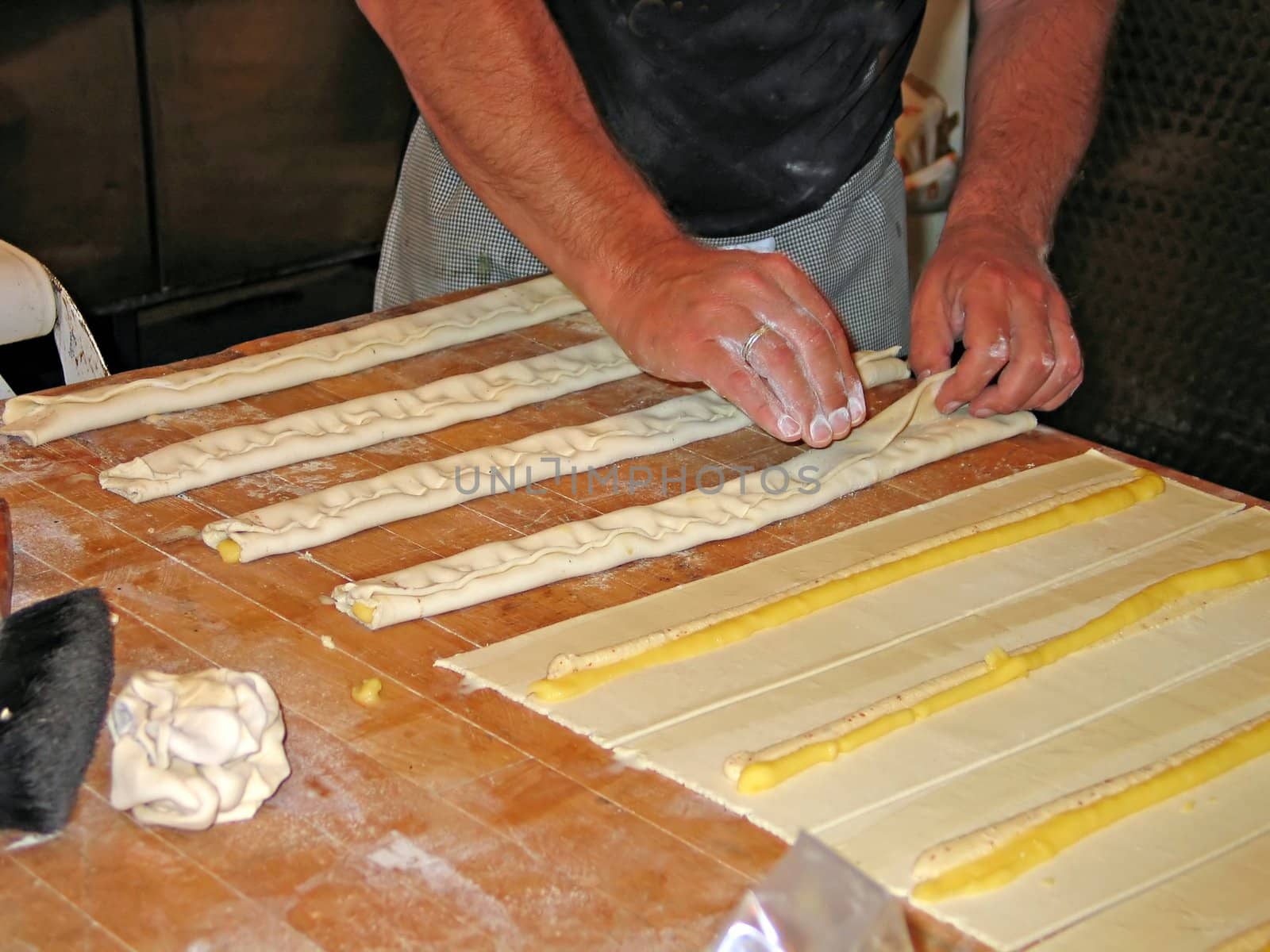 Baker with tray of cakes just before going into the oven