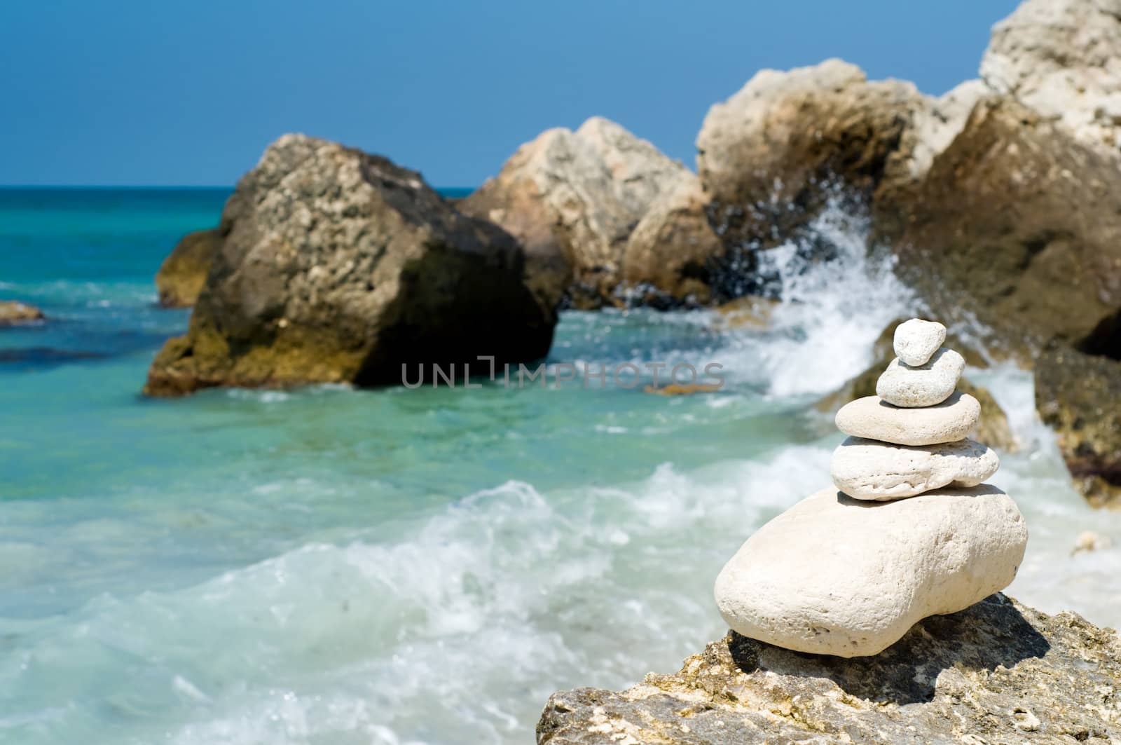 stacked limestone pebbles on the beach, blurred background