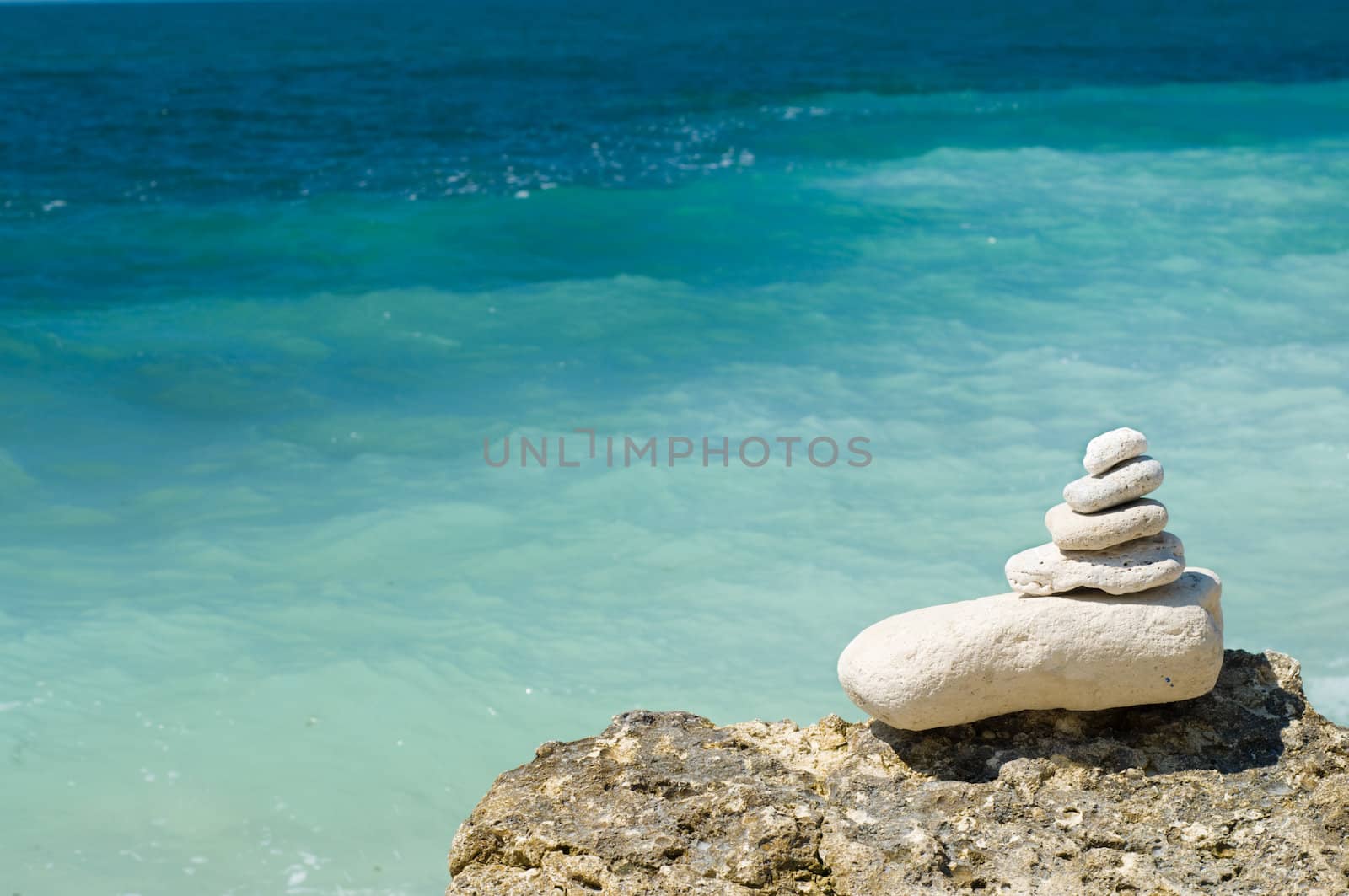 stacked limestone pebbles on the beach, blurred background