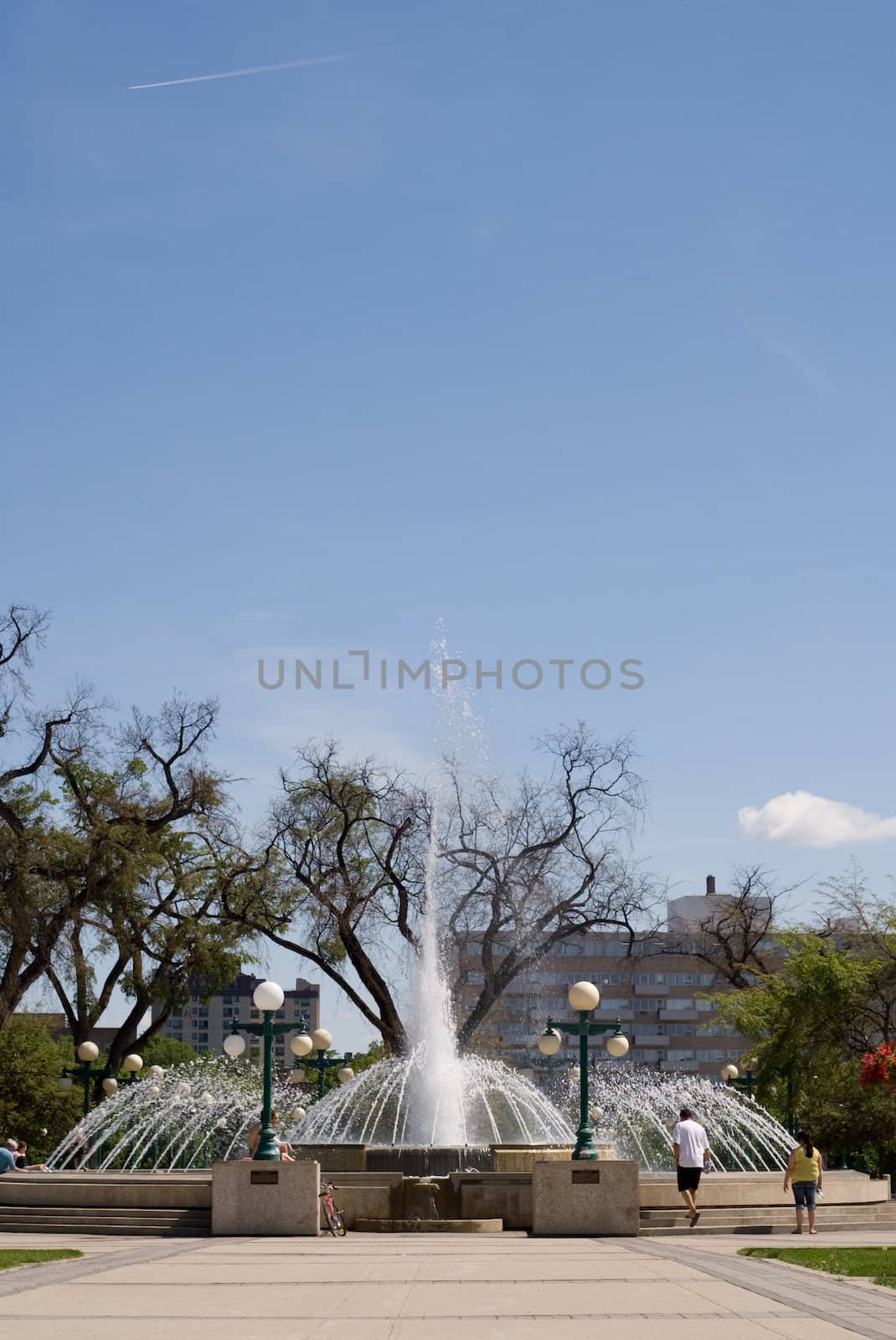 A large water fountain shot during the day, with additional space for the text in the sky