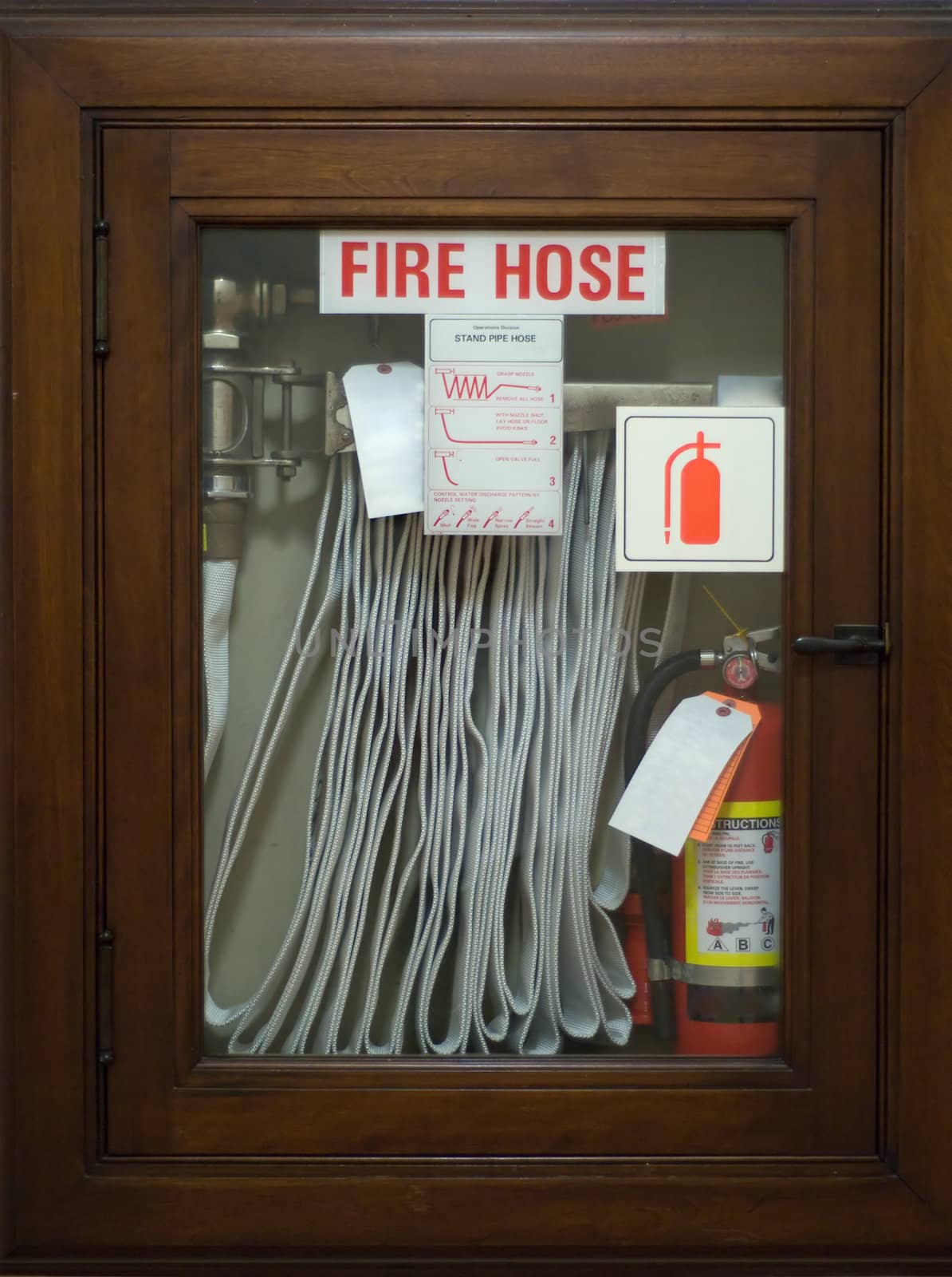 An emergency fire hose enclosed behind glass