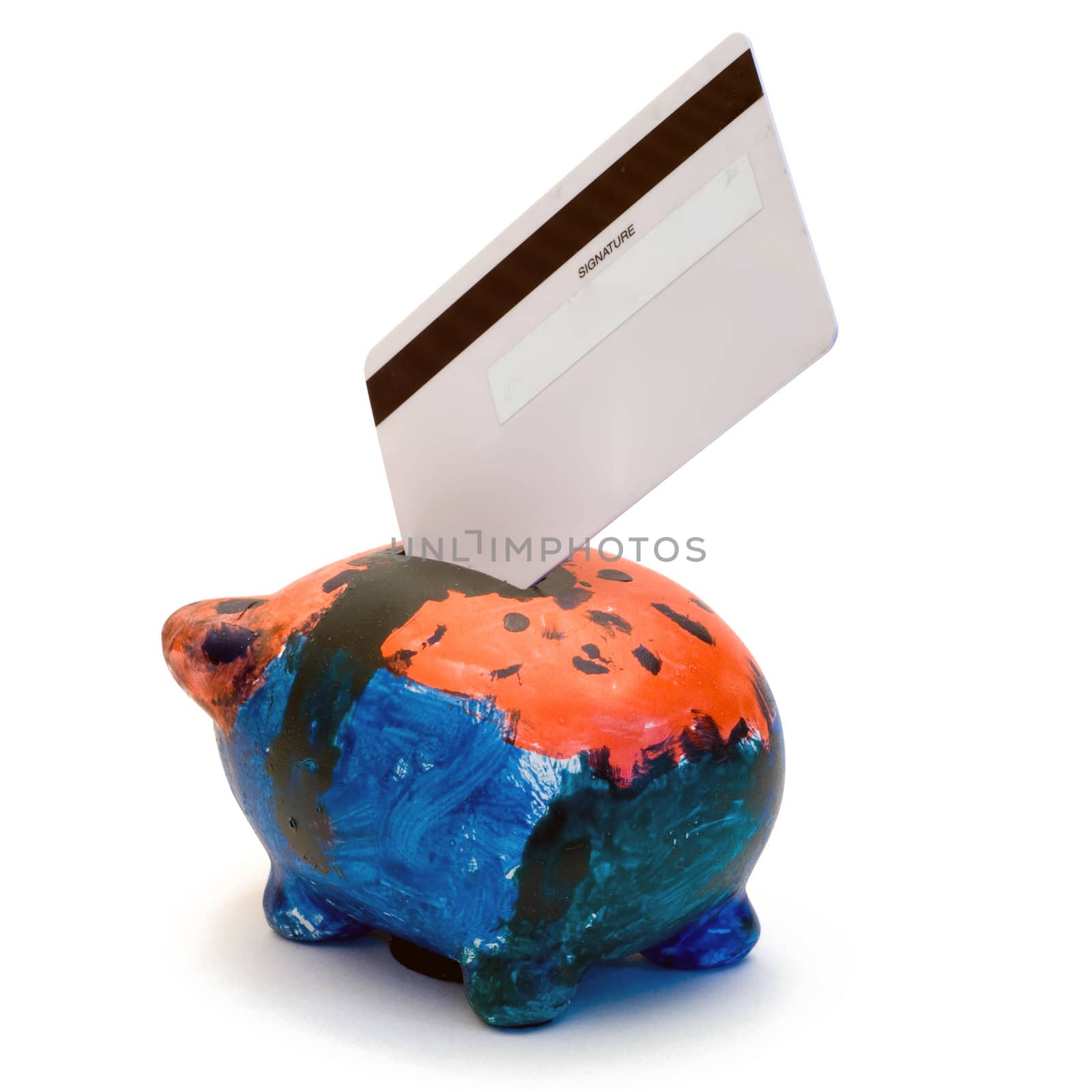 A bank card placed in a painted piggy bank, isolated on a white background