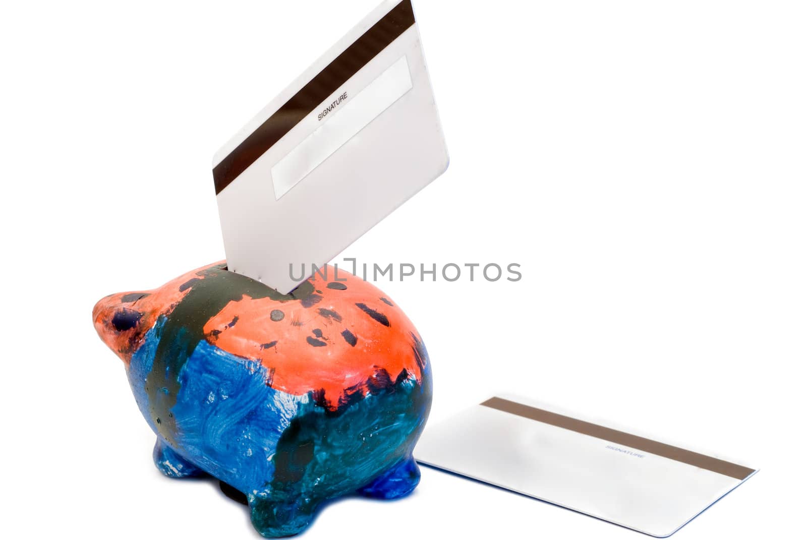 A colorful piggy bank with two bank cards, isolated on a white background