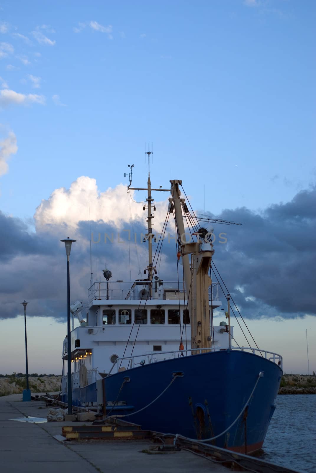 A large ship docked at the marina, shot during the evening