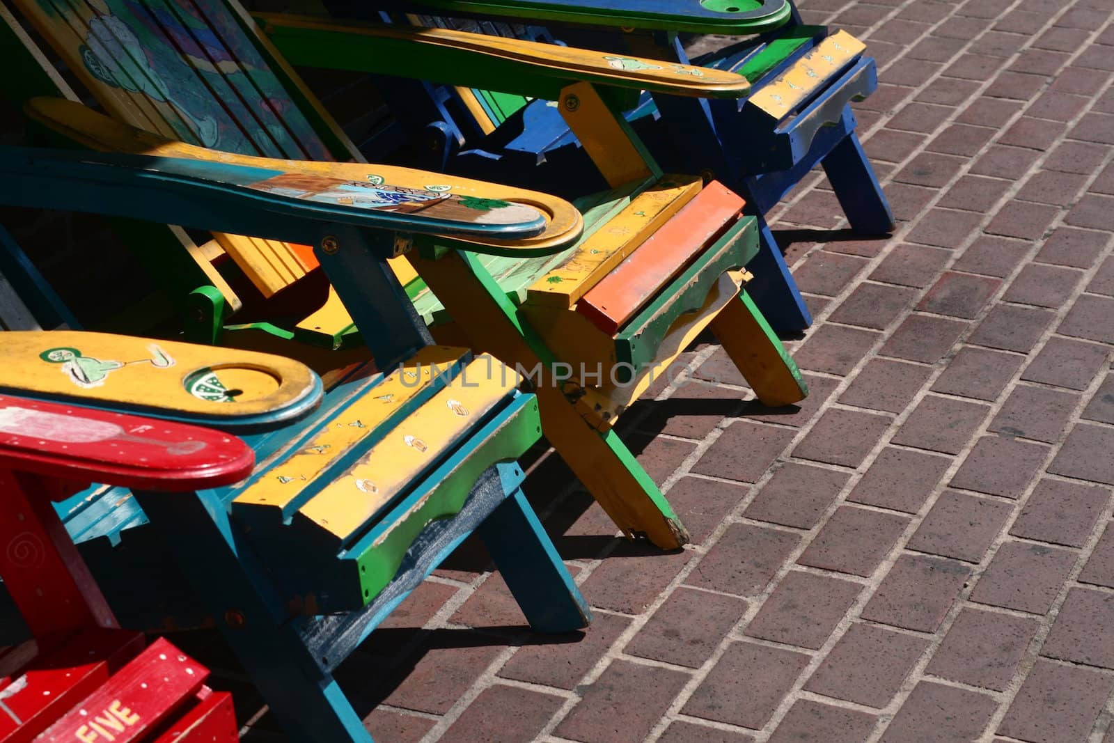 A group of very colorfully painted wooden chairs.