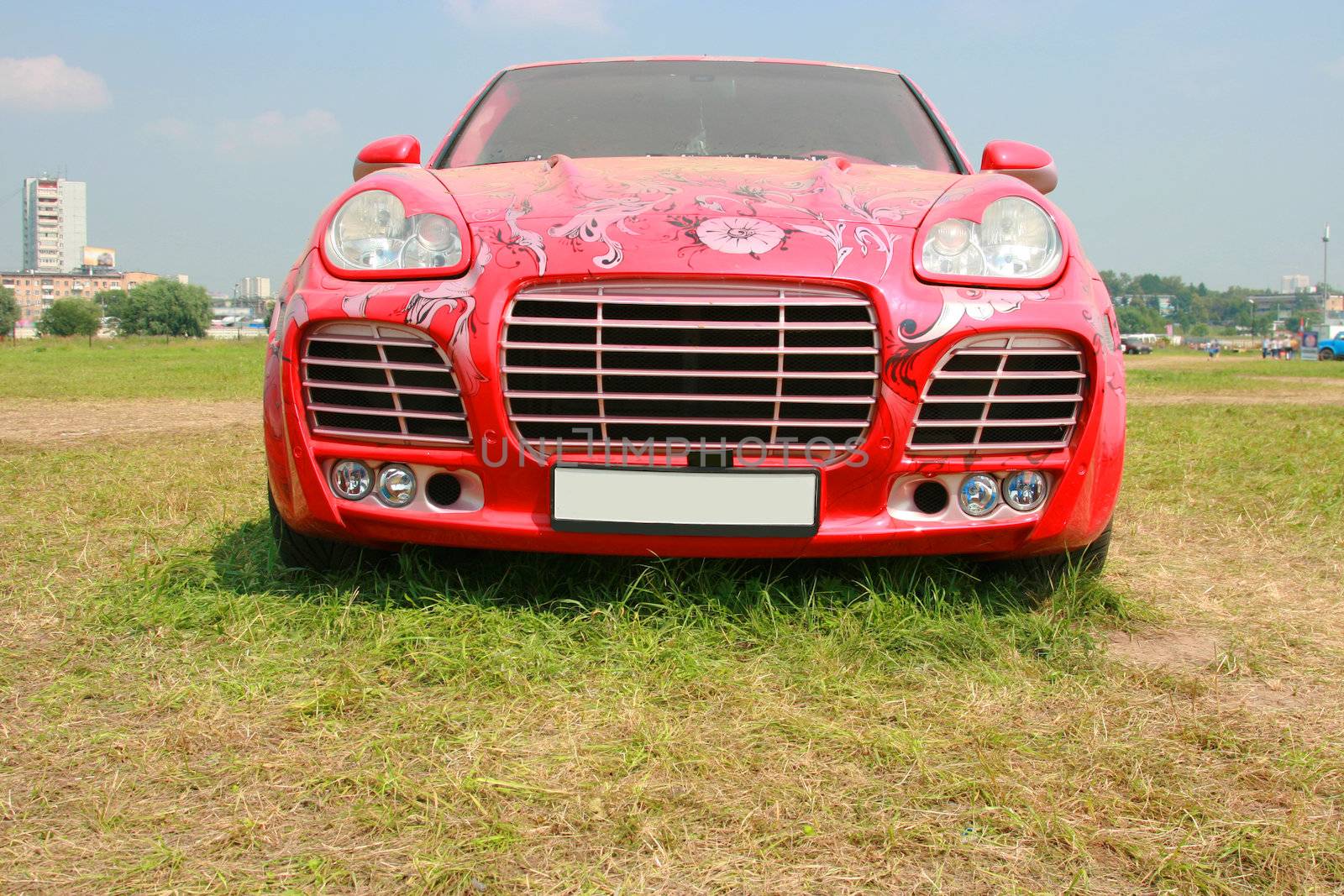 The luxury car of red color at an exhibition