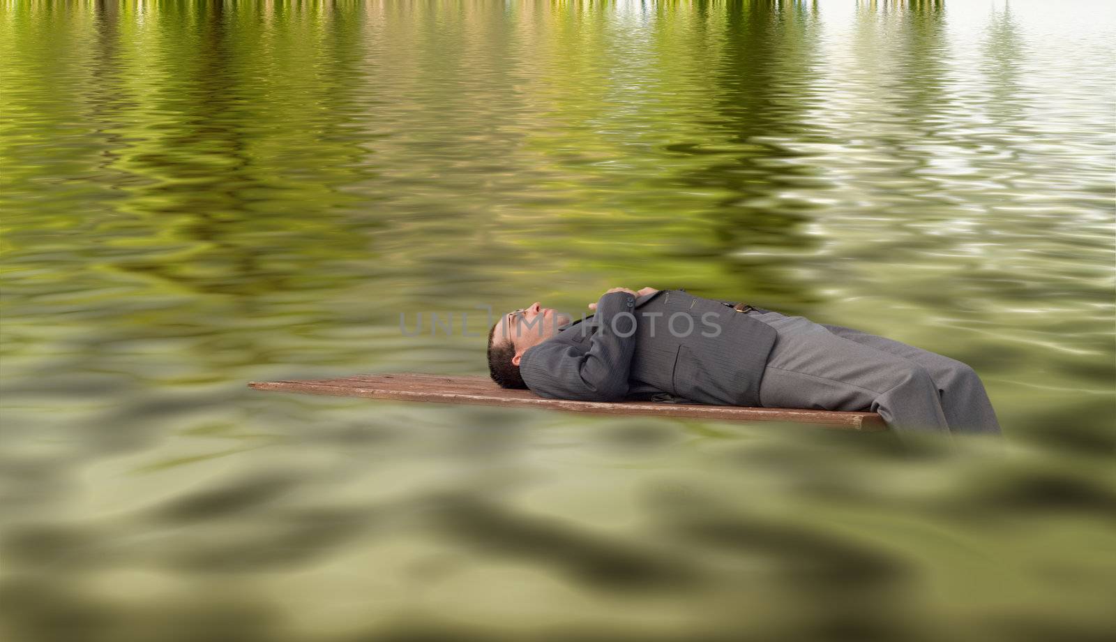 A young businessman stranded on some drift wood, floating on some water