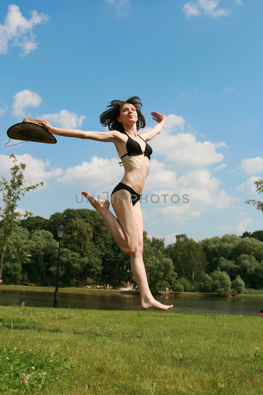 The girl jumps above the ground in a sunny day