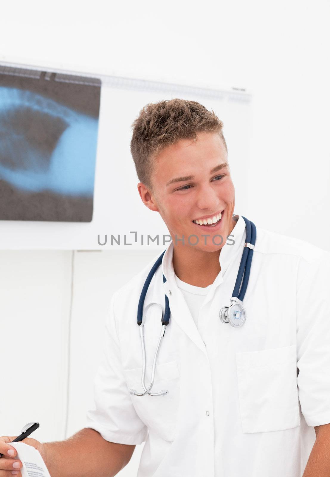 Smiling young doctor with phonendoscope having good news about patient diagnosis;