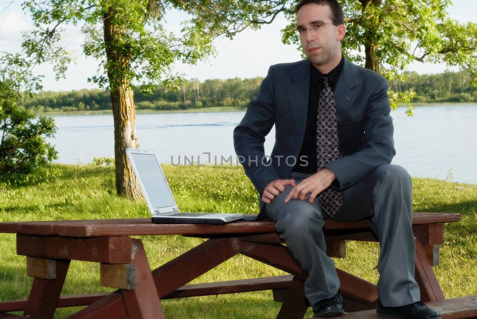 A young businessman working outside in a park