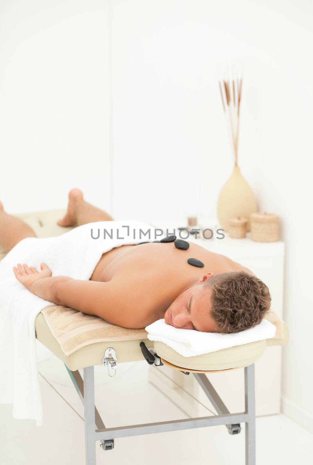 Young blond handsome man enjoying spa treatment
