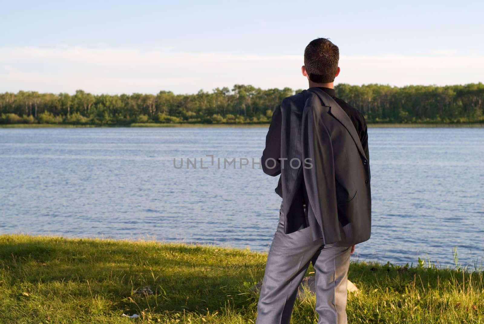 A young businessman at the lake after work