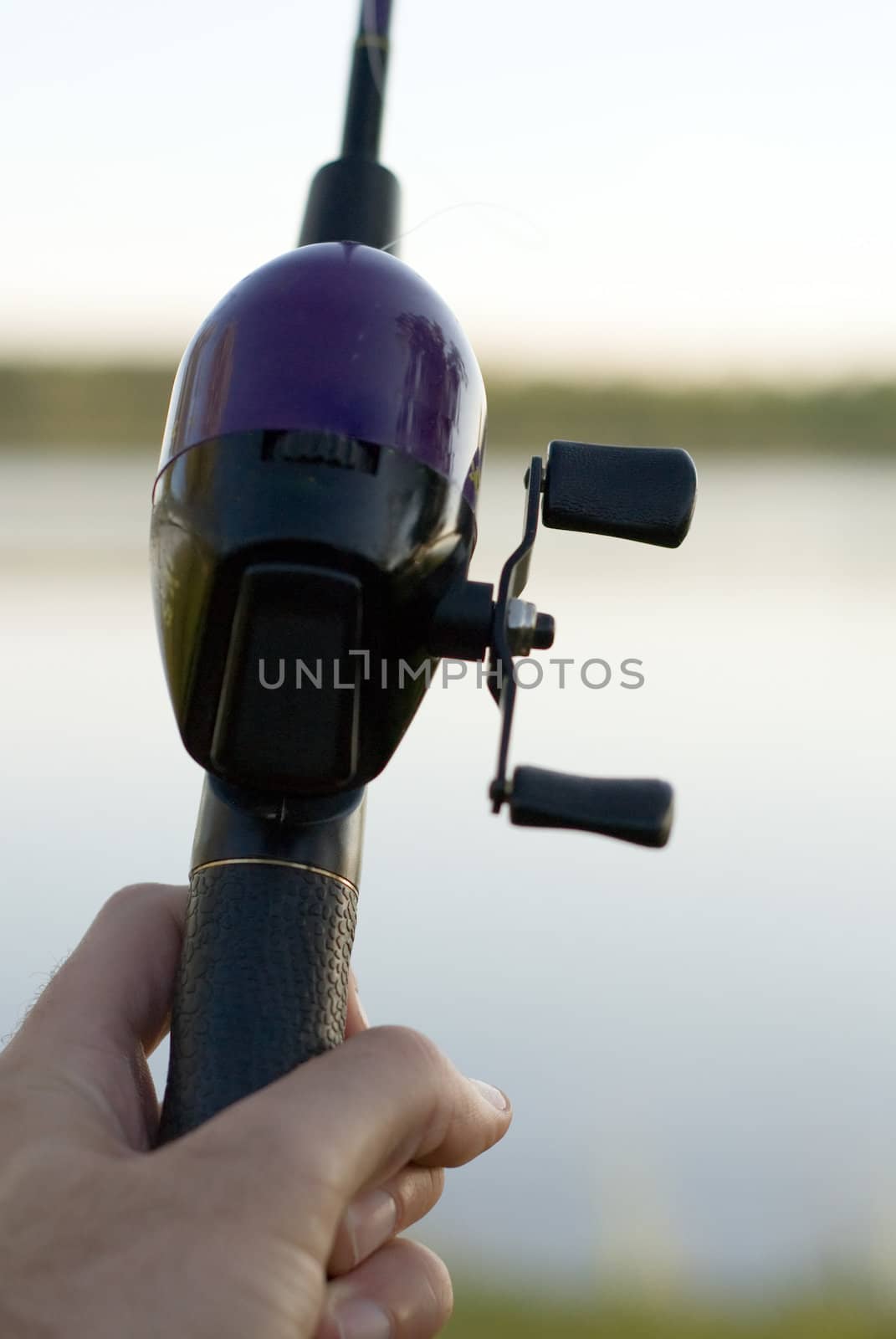 Close-up of a hand and a fishing pole