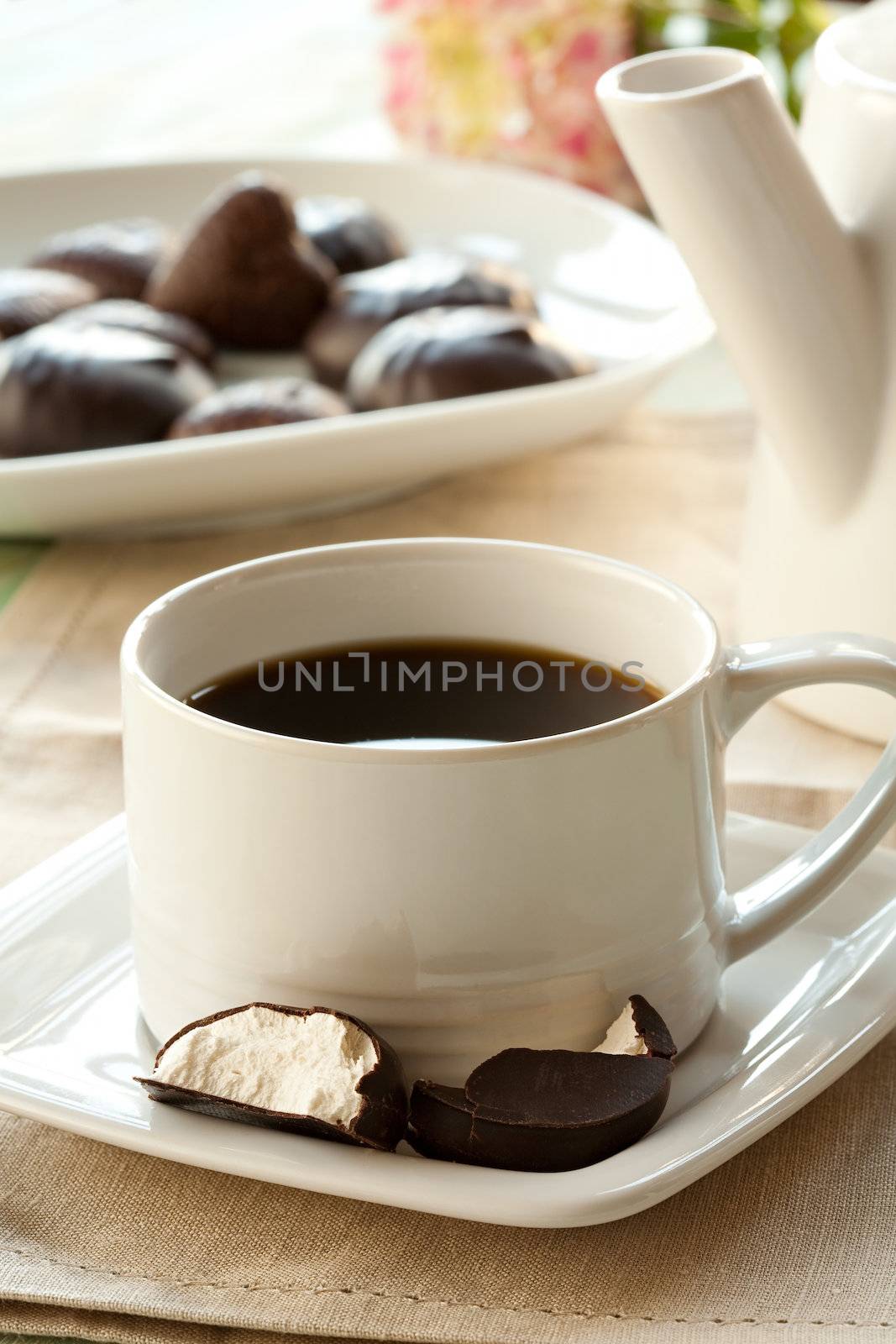 A cup of coffee, zephyr in chocolate and candy