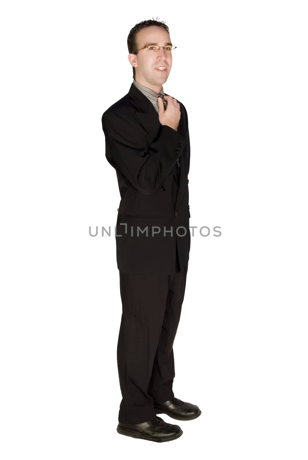 Young business man fixing his tie, isolated against a white background