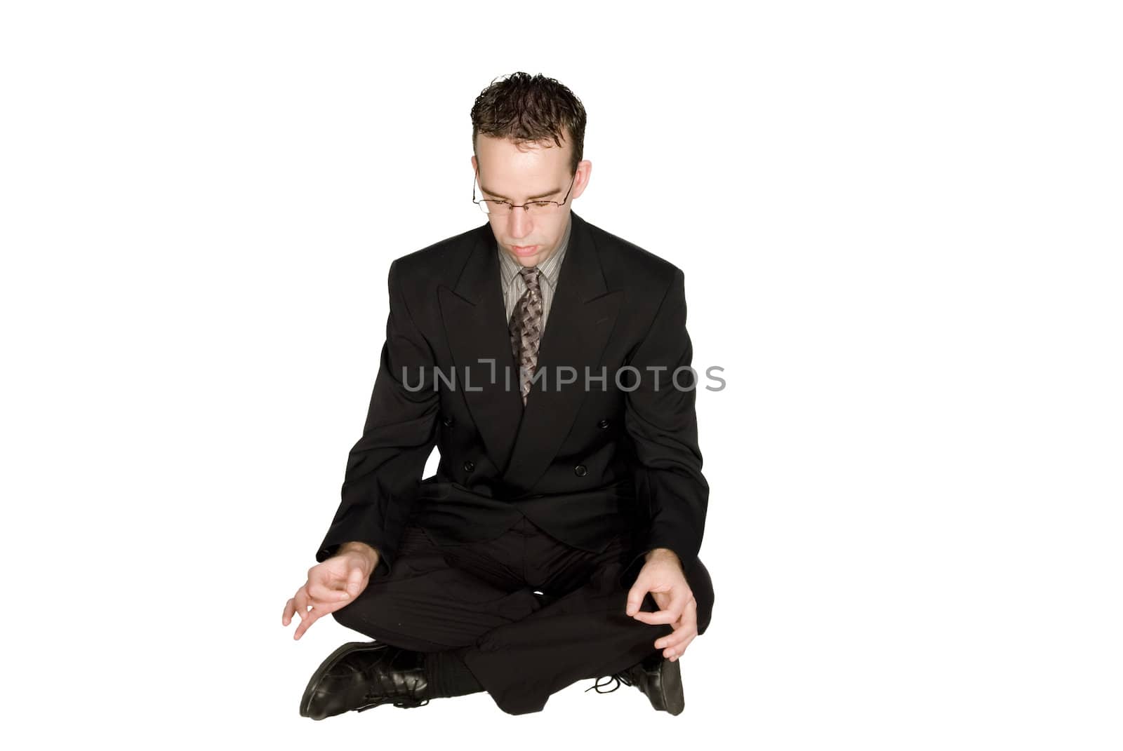 Businessman meditating and relaxing isolated against a white background