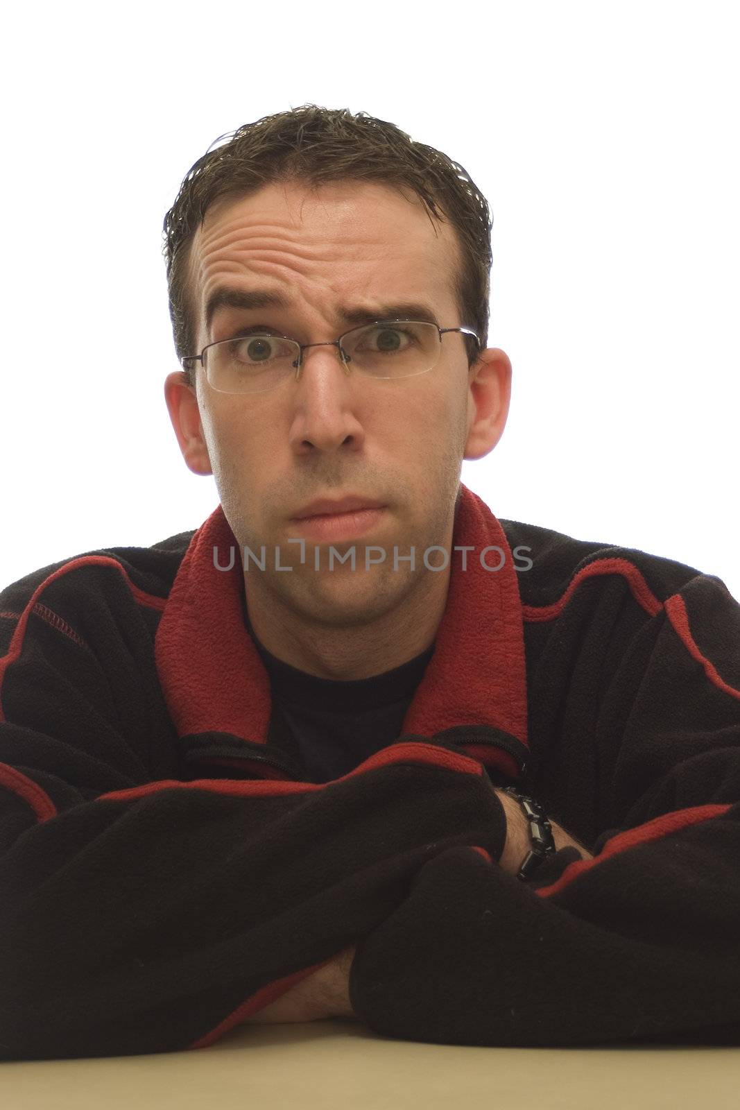 Thin young man looking into the camera, making a funny face, isolated against a white background