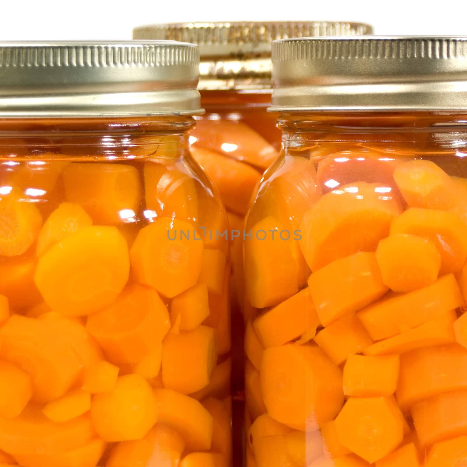 Macro view of three mason jars of canned carrots